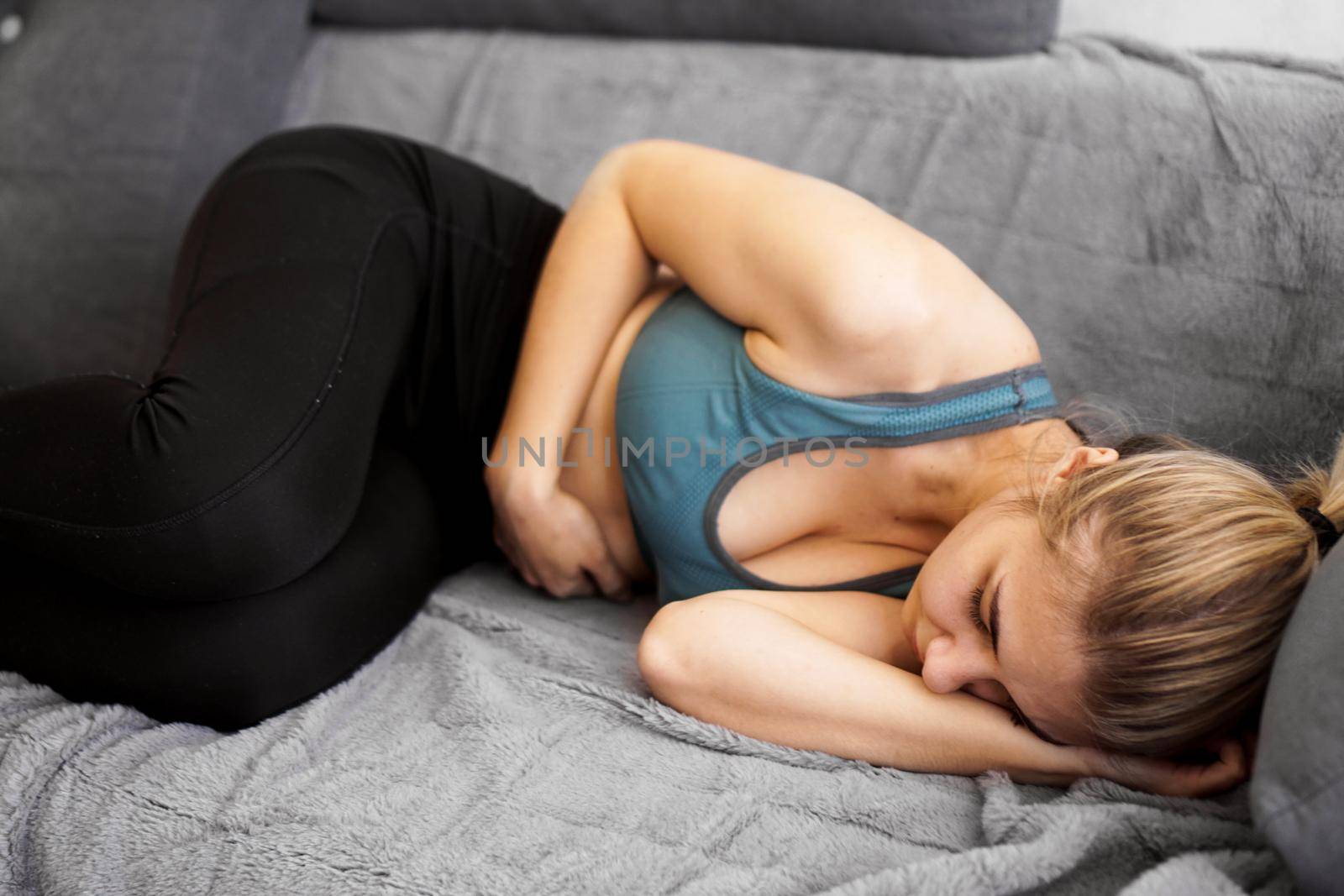 After the workout. Nice young woman sleeping on the sofa by natali_brill