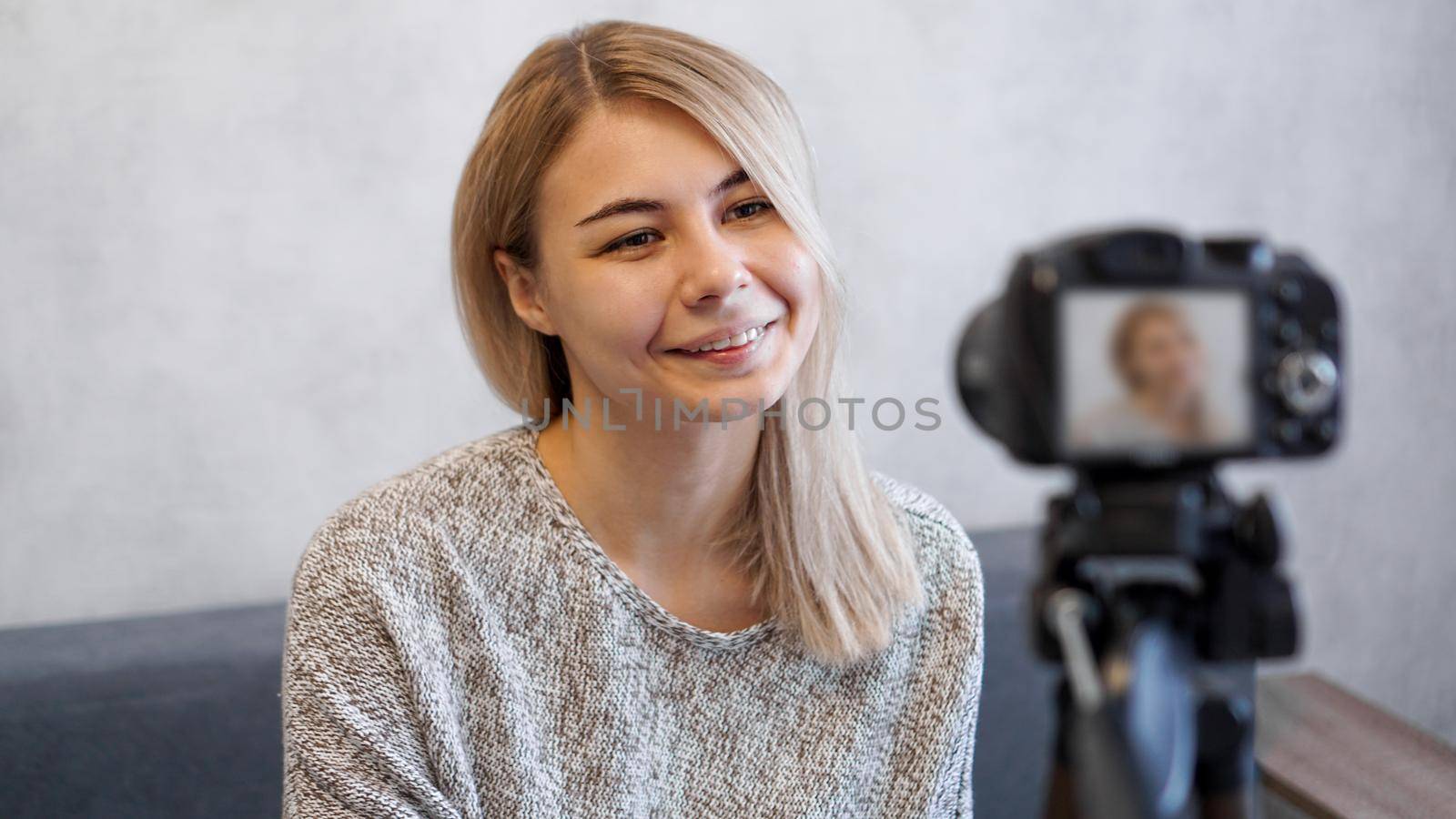 Cheerful female blogger recording video at home