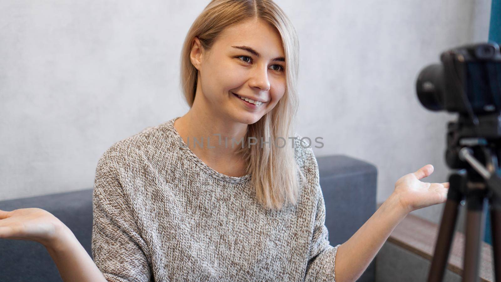 Cheerful female blogger recording video at home