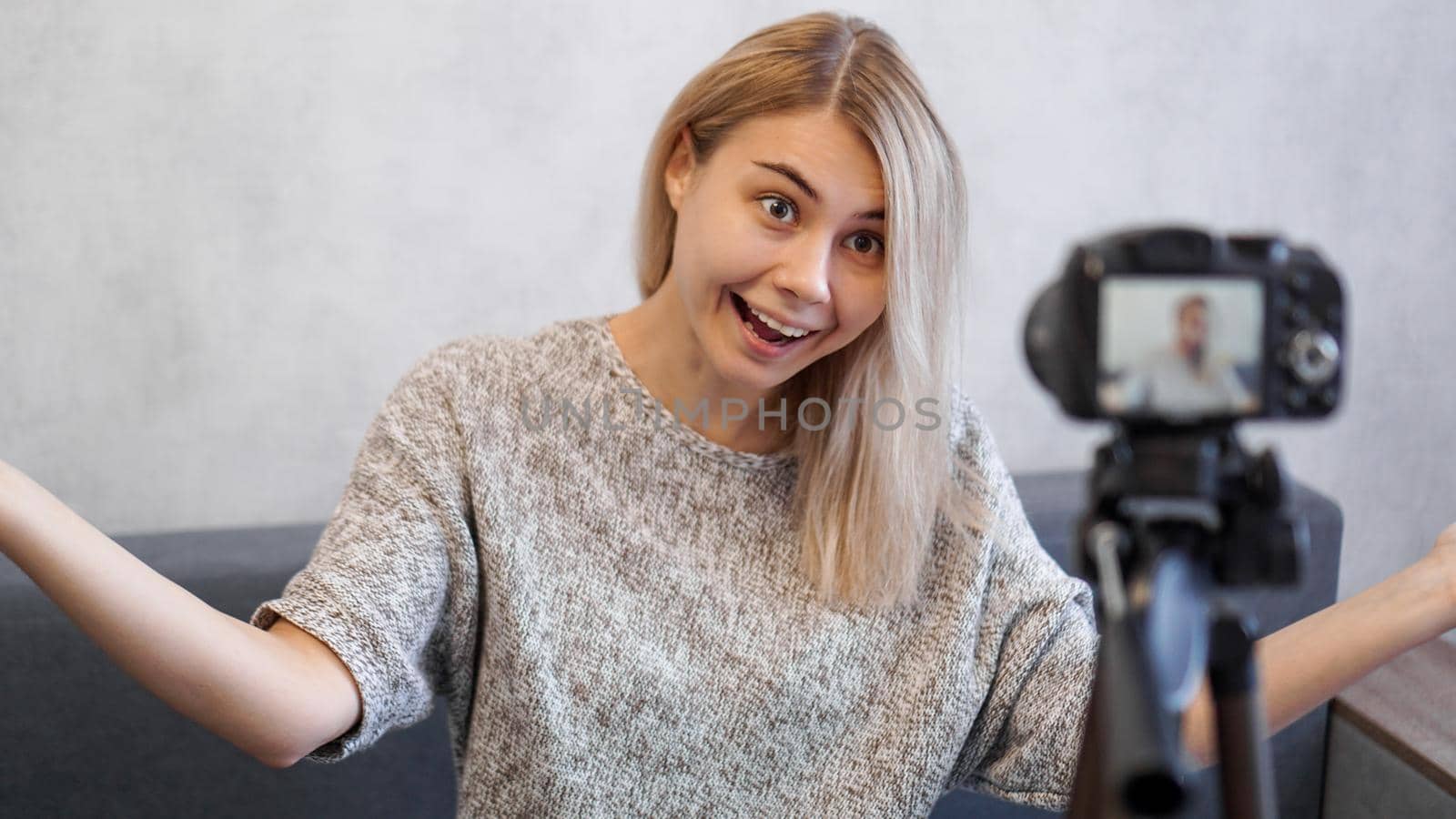 Cheerful female blogger recording video at home