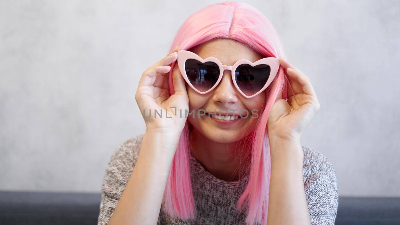 Woman wearing heart-shaped glasses and pink wig - positive portrait