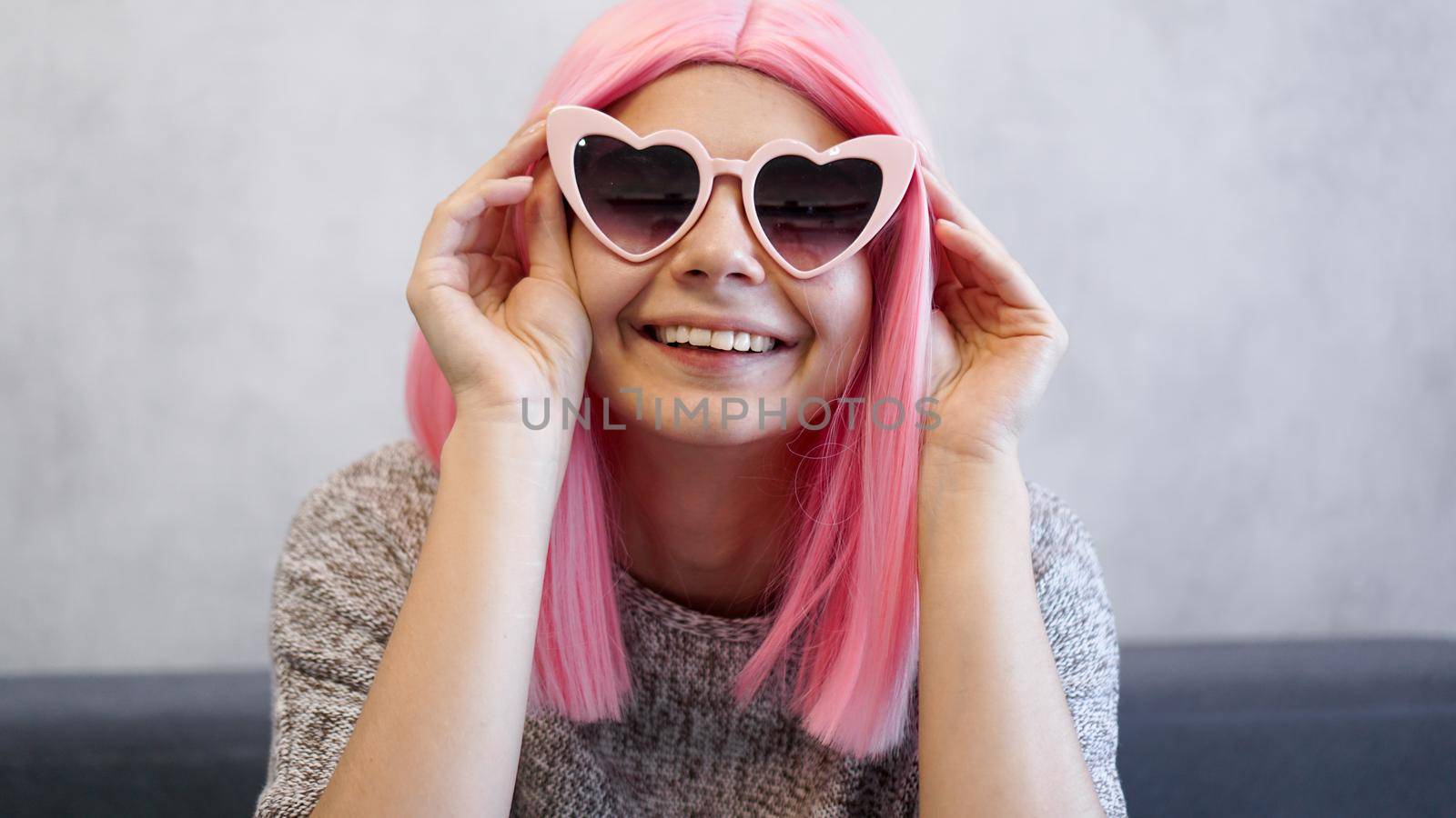 Woman wearing heart-shaped glasses and pink wig - positive portrait