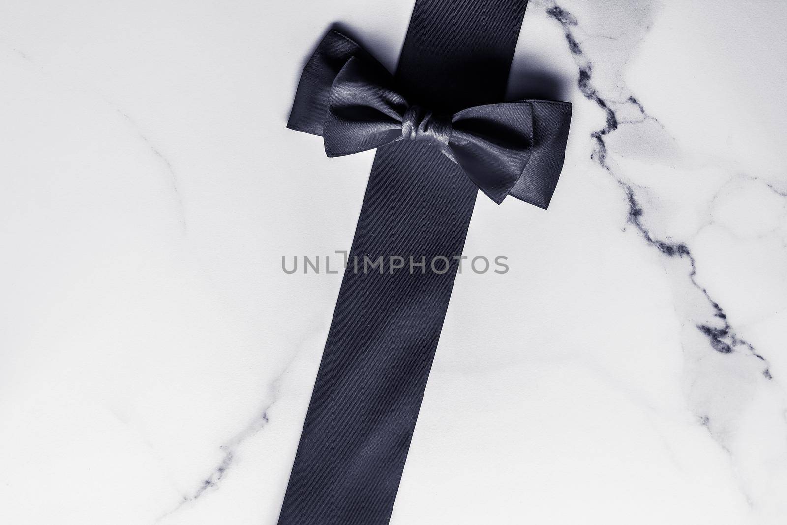 Holiday gift, decoration and sale promotion concept - Black silk ribbon and bow on marble background, flatlay