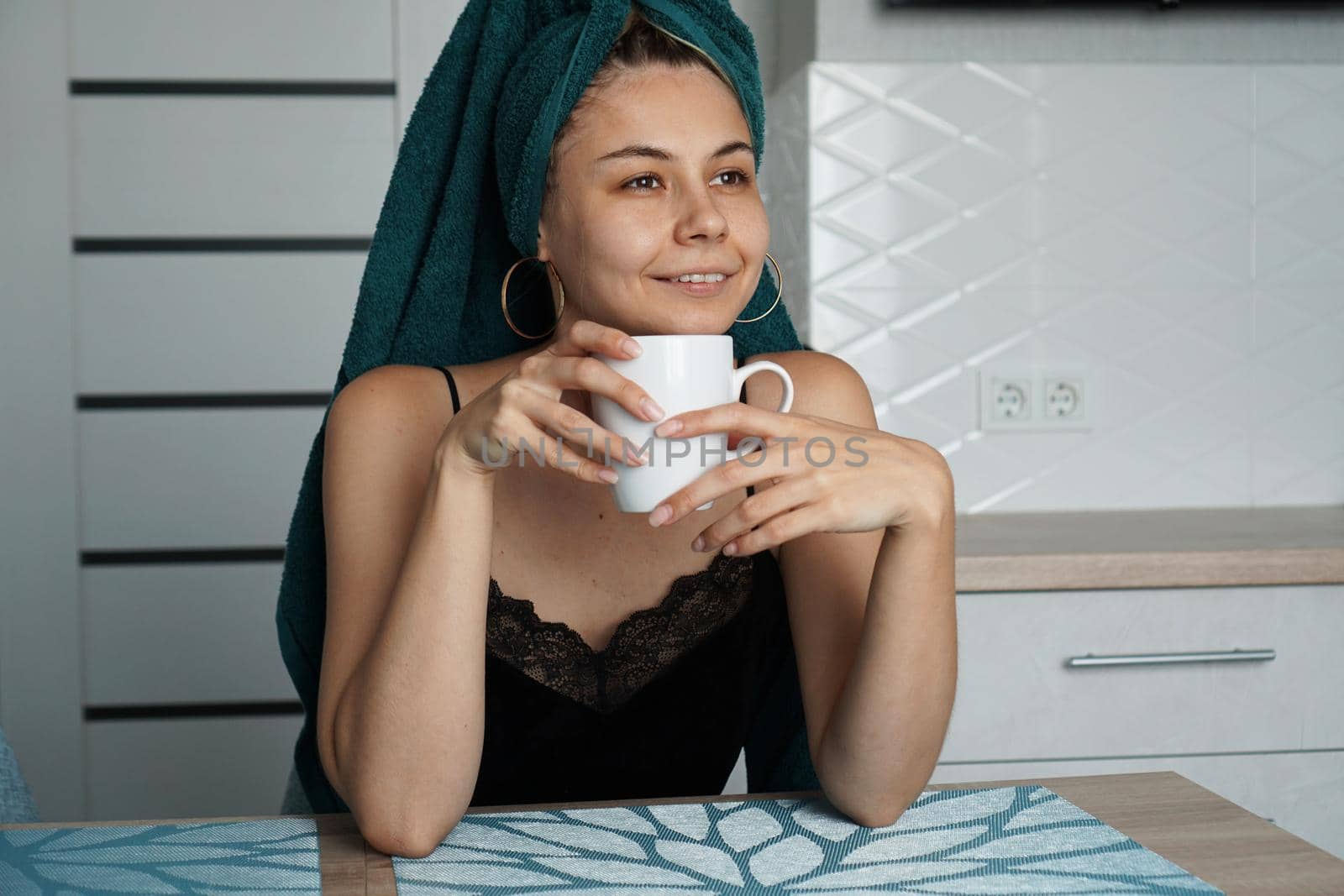 Beautiful woman in a towel on hair with a cup of coffee
