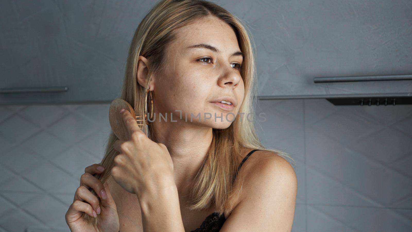 Young beautiful woman straightening her hair by natali_brill