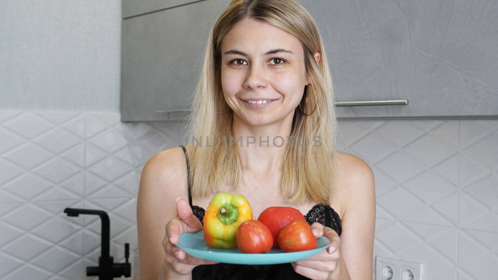 Woman holding plate with fresh vegetables and smiling by natali_brill