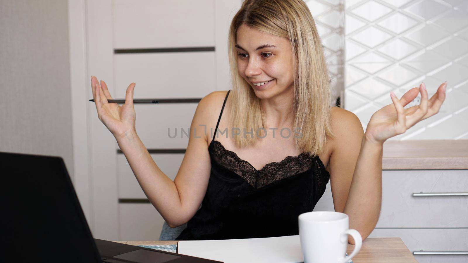 Excited young beautiful woman with arms raised using looking at her laptop screen. Unexpected pleasant good news