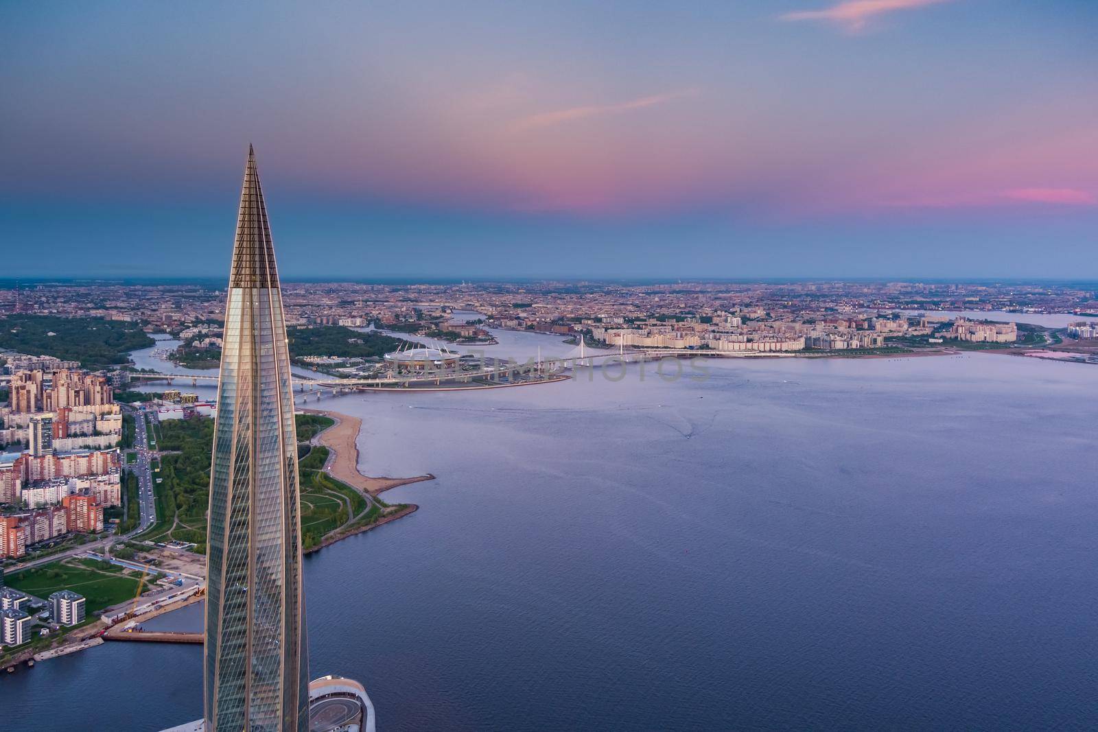 Russia, St.Petersburg, 16 May 2021: Drone point of view of highest skyscraper in Europe Lakhta Center at pink sunset, Headquarters of the oil company Gazprom, stadium Gazprom Arena on background. High quality photo