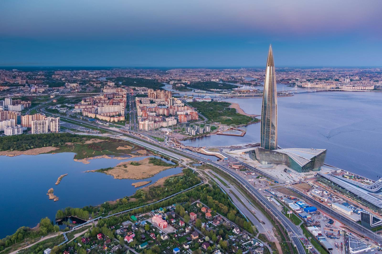 Russia, St.Petersburg, 16 May 2021: Drone point of view of highest skyscraper in Europe Lakhta Center at pink sunset, Headquarters of the oil company Gazprom, stadium Gazprom Arena on background. High quality photo