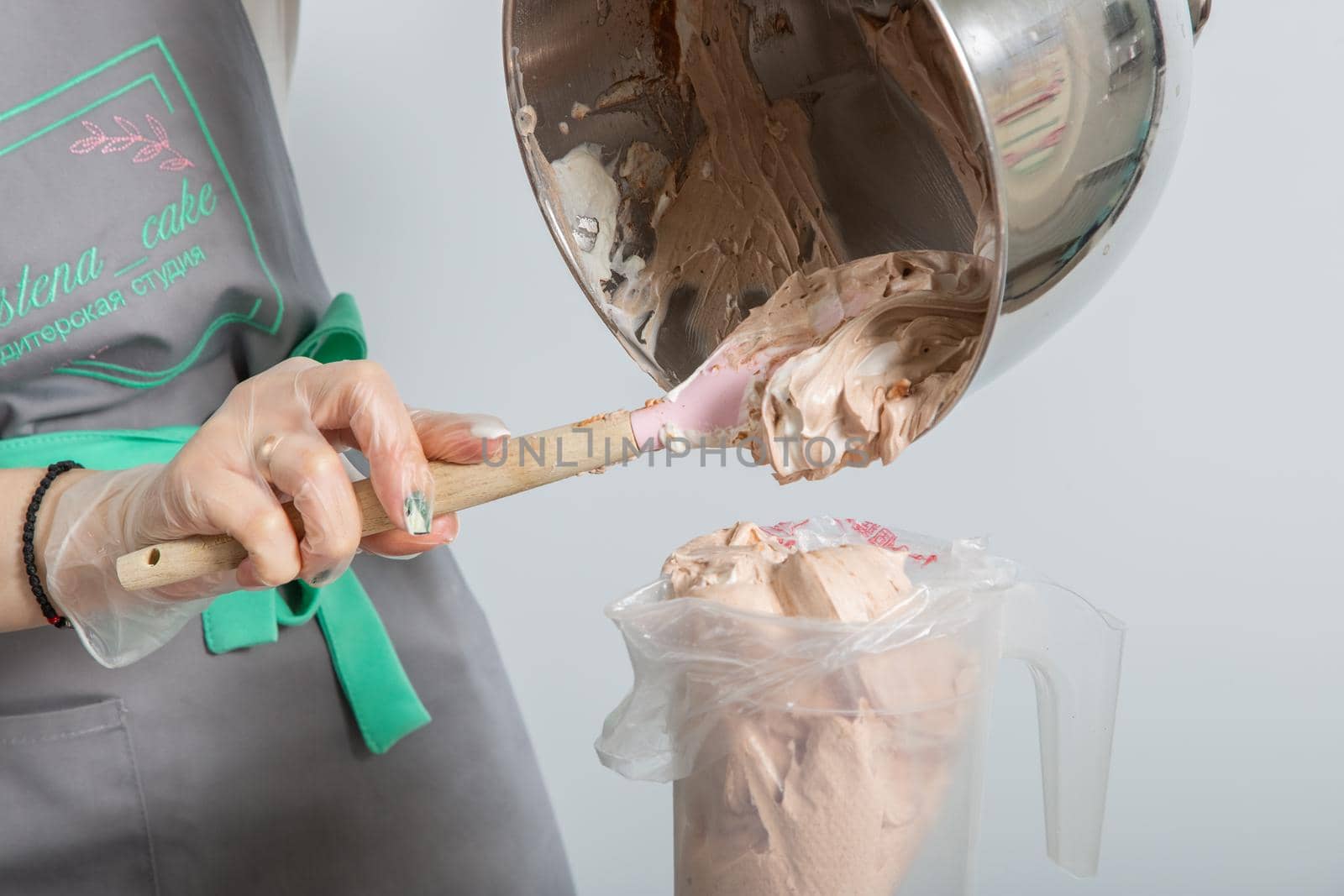 Moscow, Russia - April 18, 2021: Confectioner puts cream in a pastry bag.