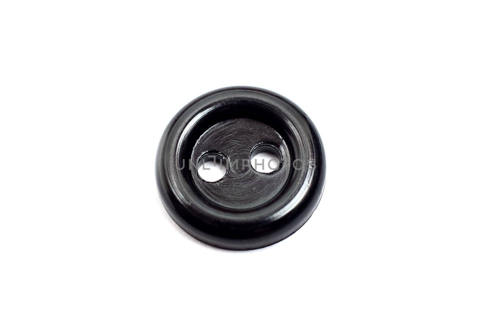 One black plastic button close up, isolate on white background