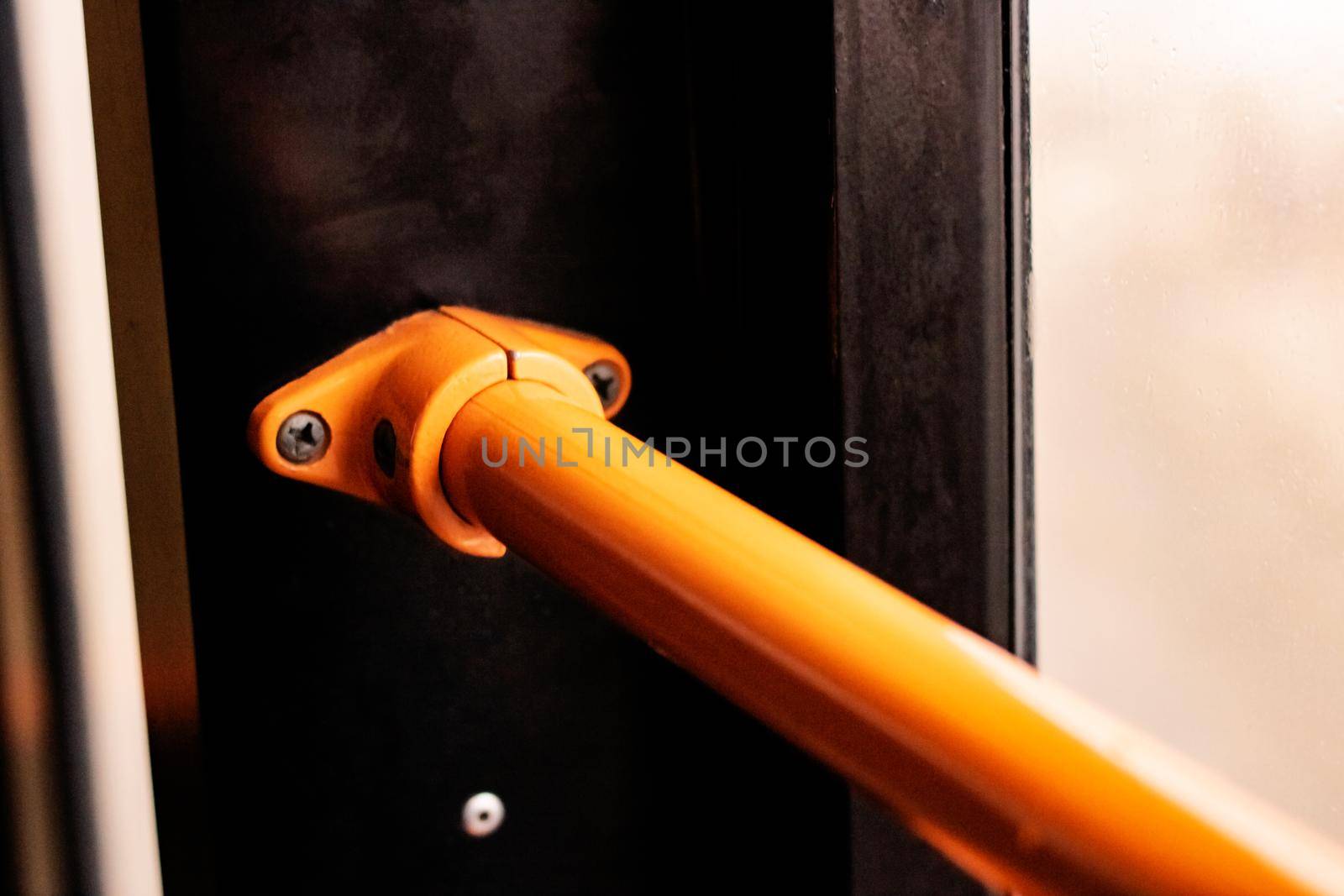 Orange handrail in the bus close up with copy spcace