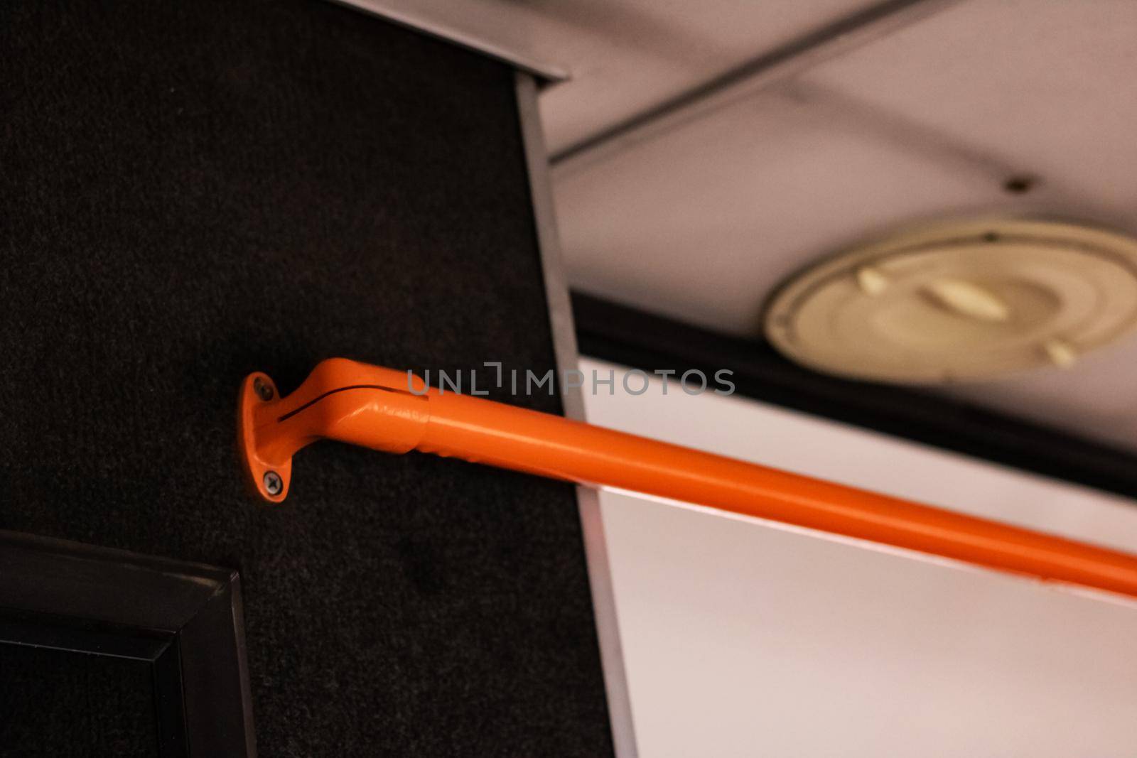 Orange handrail in the bus close up with copy spcace