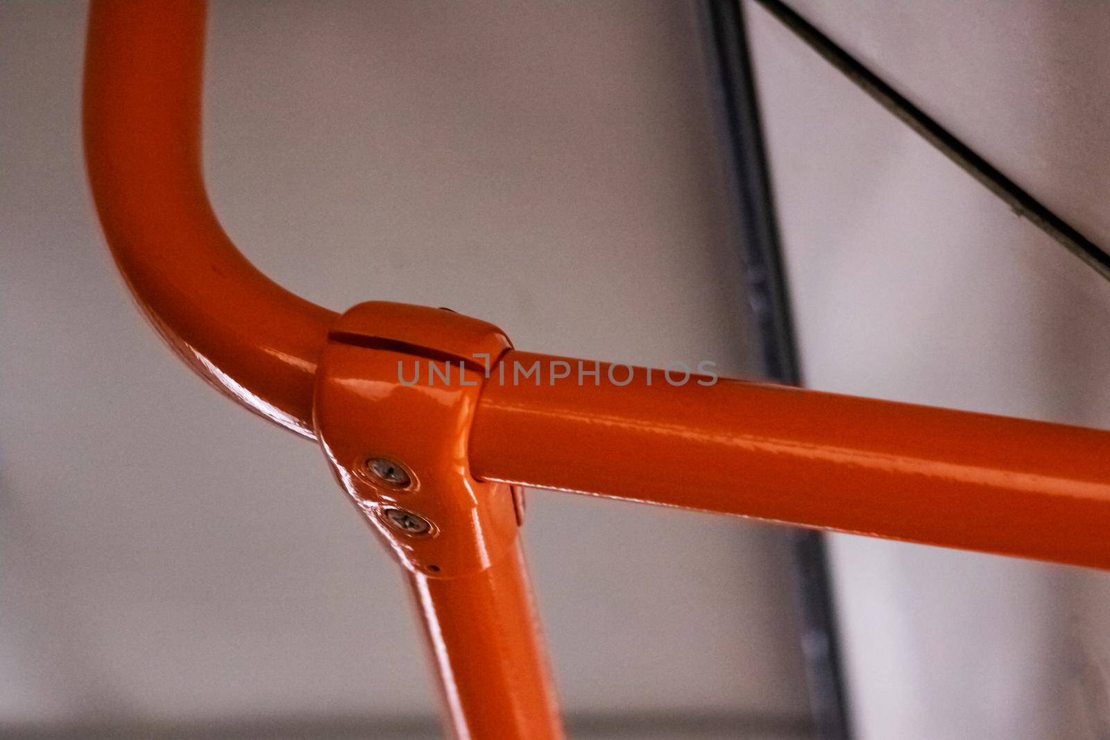 Orange handrail in the bus close up by Vera1703