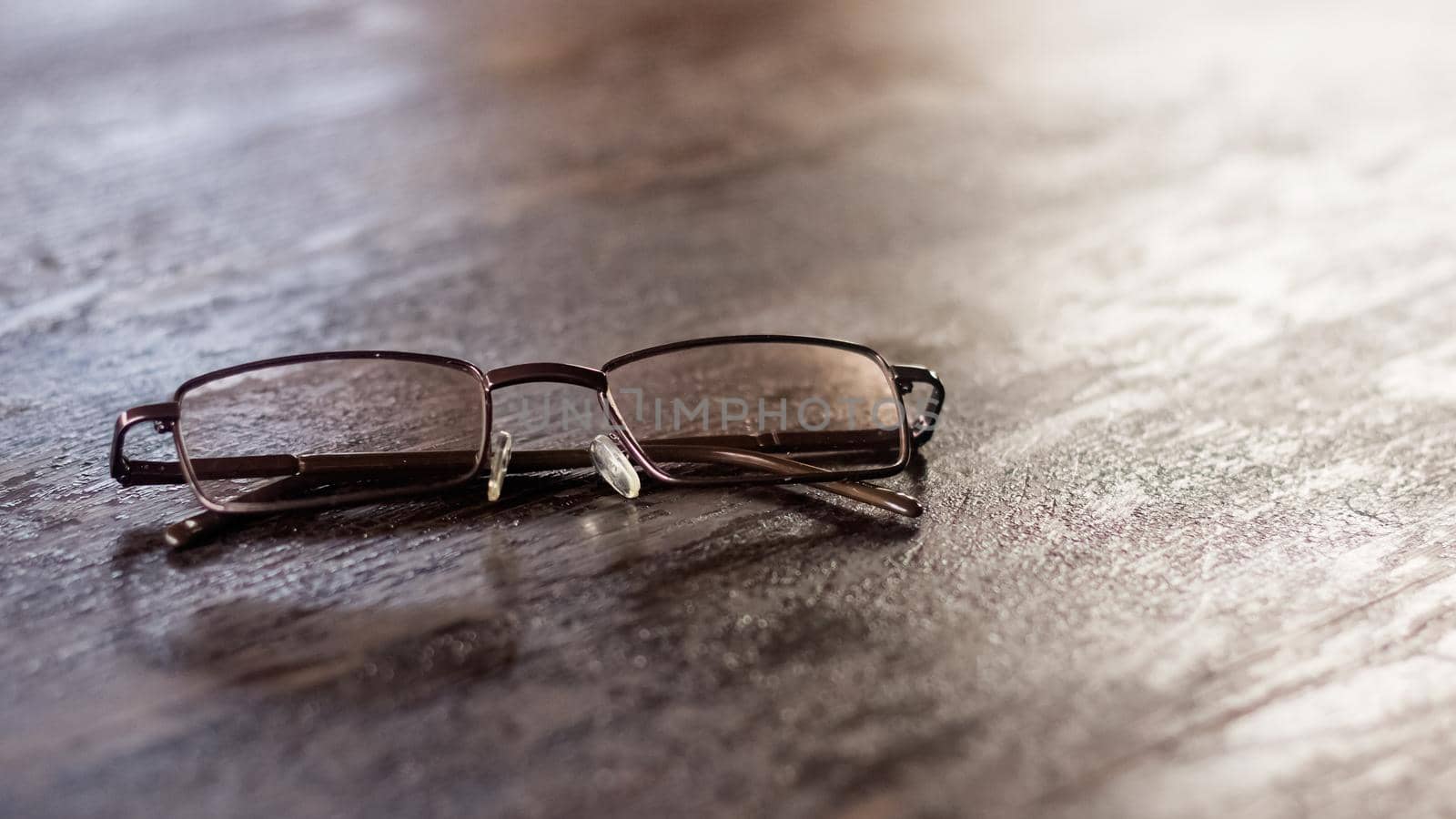 Glasses on a wooden table close up, the sun's rays from the window