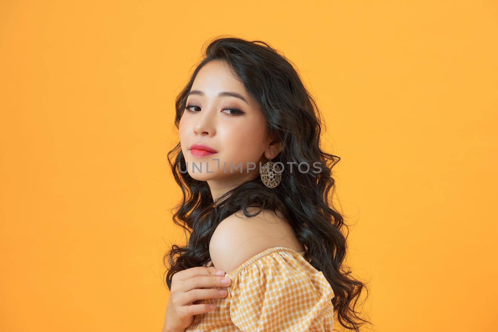Fashionable young asian woman posing in studio by makidotvn