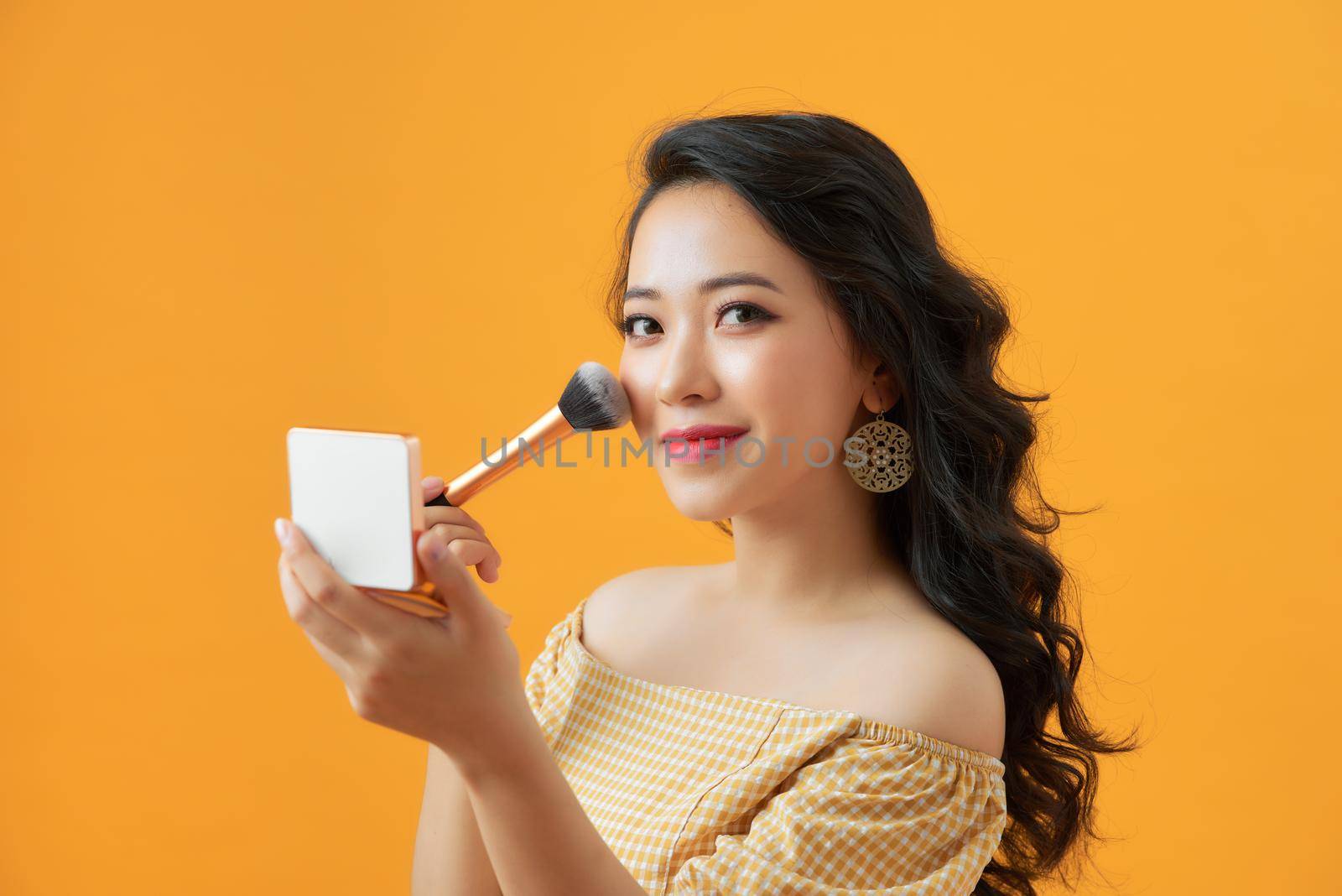 Portrait of attractive young Asian woman with beautiful skin holding brush for make up. by makidotvn