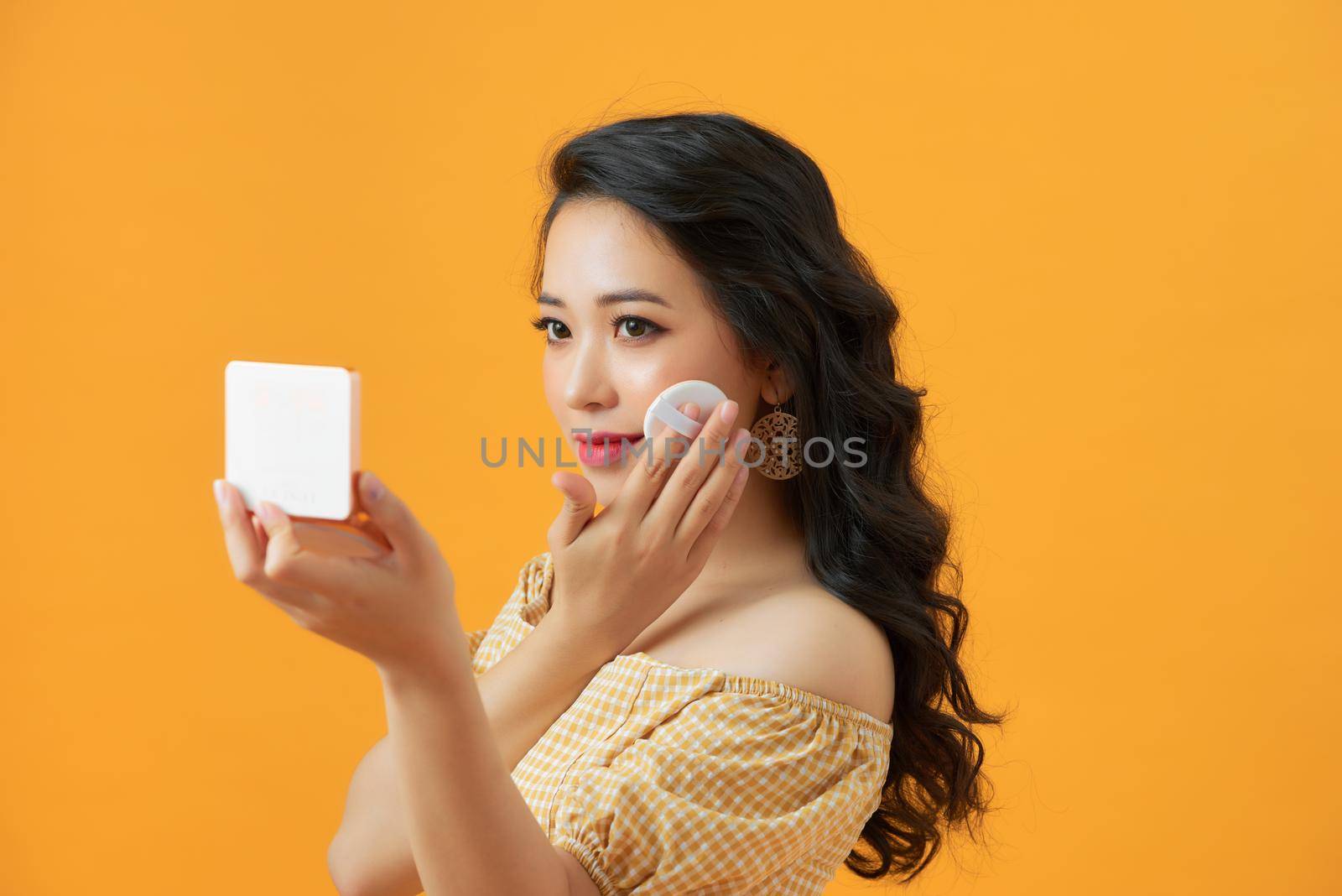 Woman using powder to touch up on her face