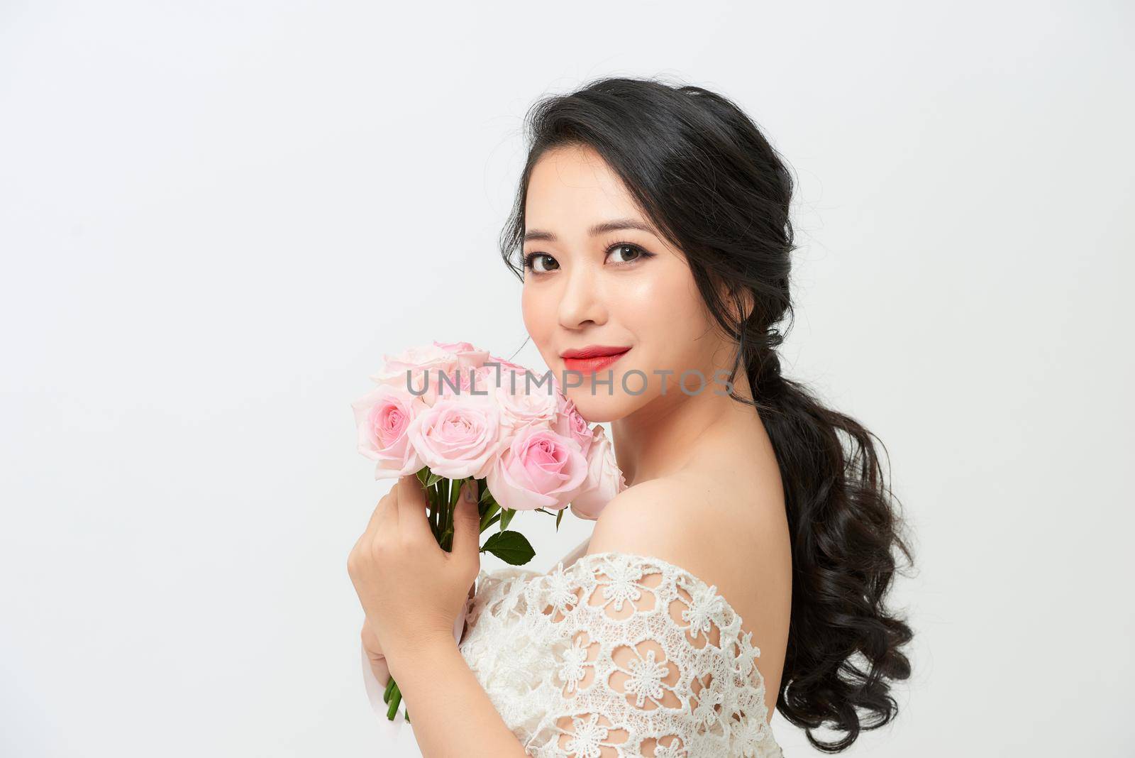 Young attractive Asian model like a bride with bridal bouquet at studio looking by makidotvn