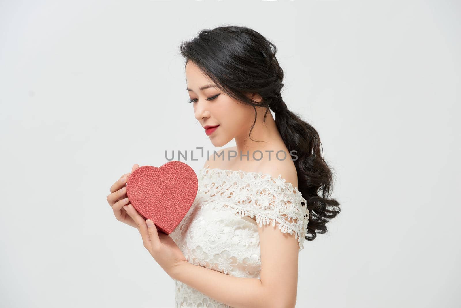 Young beautiful asian bride female in white dress with hands holding model heart red color,Happy and smiling by makidotvn