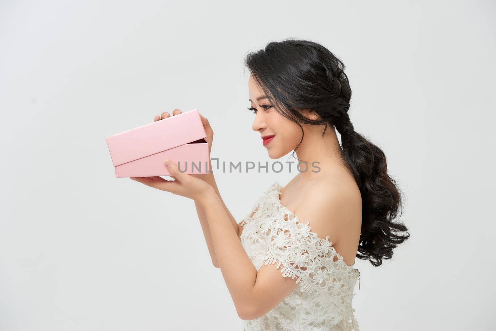 attractive smile surprised beautiful woman bride with makeup in chic sexy white wedding holding gift box by makidotvn