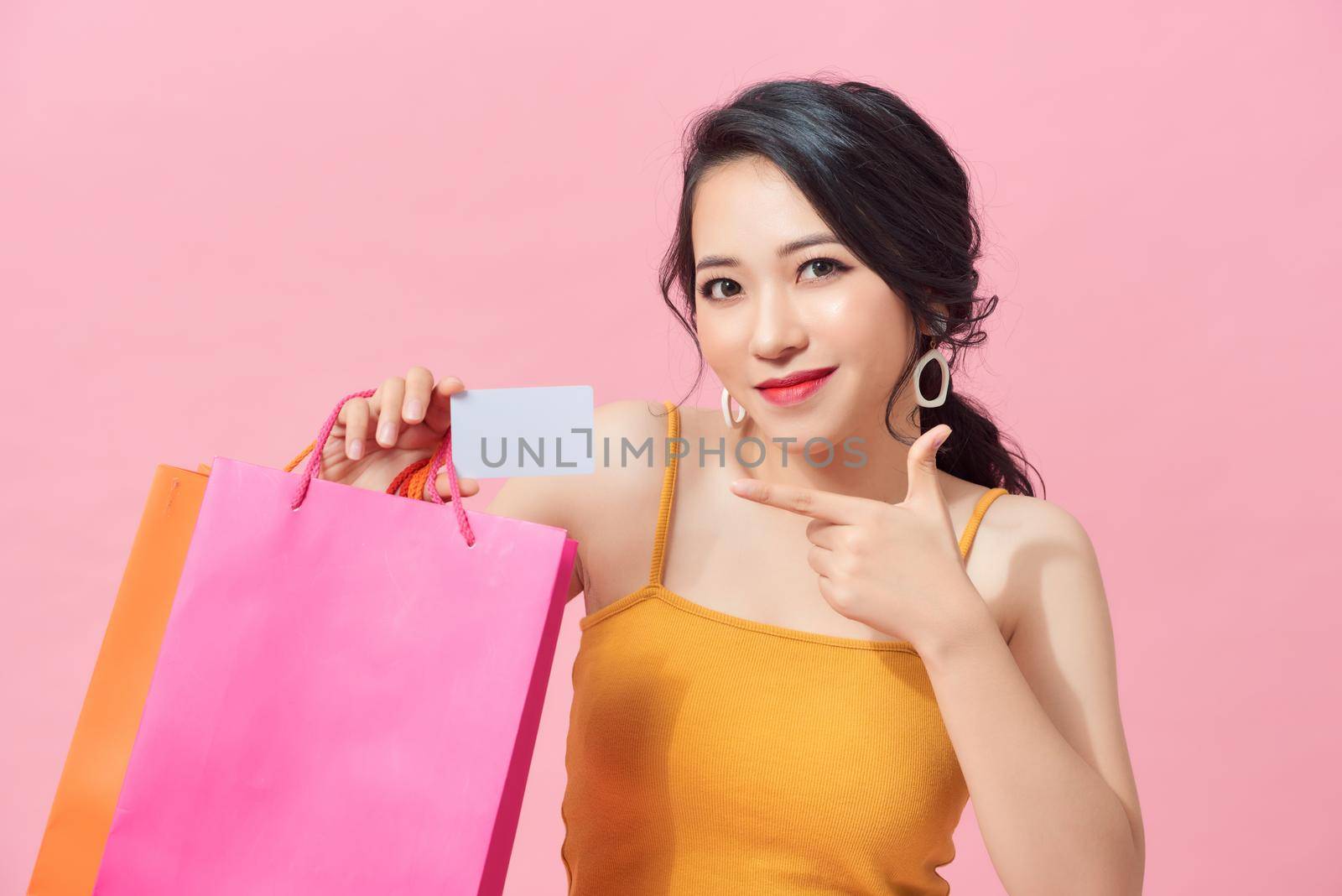 Young beautiful woman holding colorful shopping bags and a credit card by makidotvn