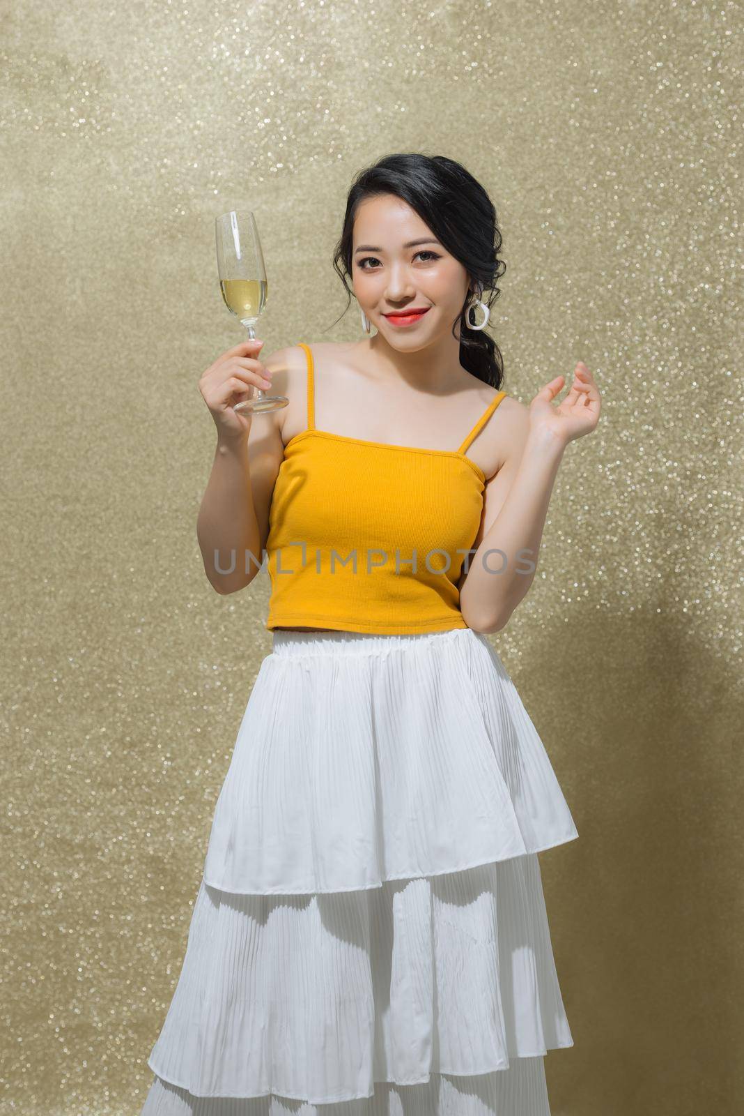 One young and beautiful woman dancing with glass of champagne and smiling. Party concept by makidotvn