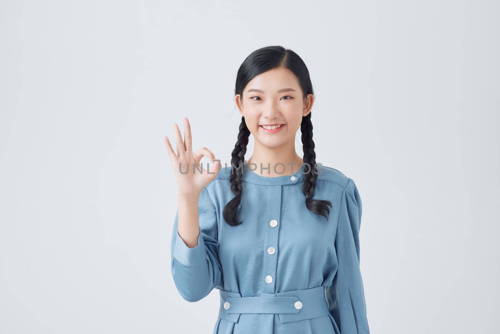 Young asian woman showing a OK hand sign.