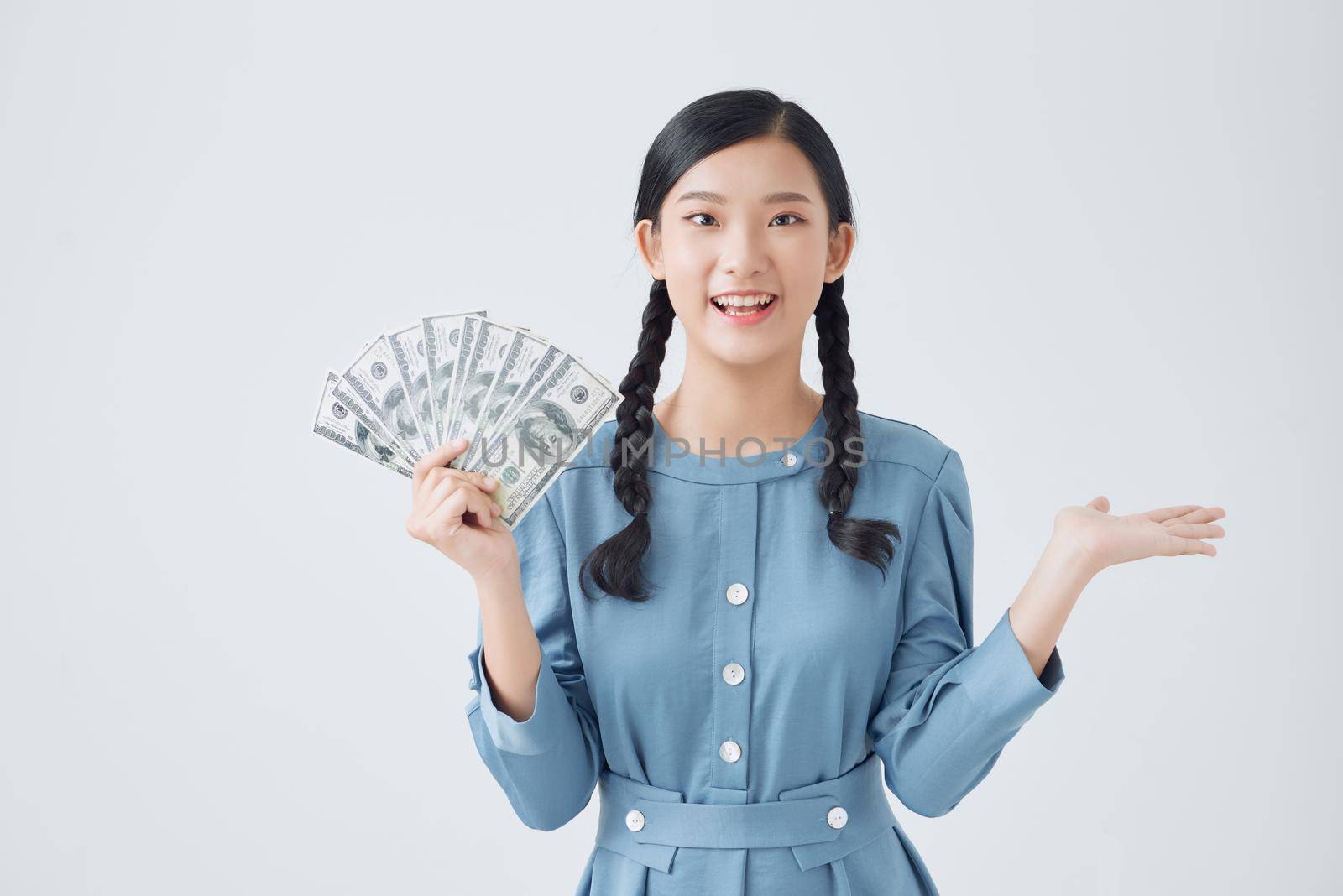 Happy young woman holding dollar currency satisfied