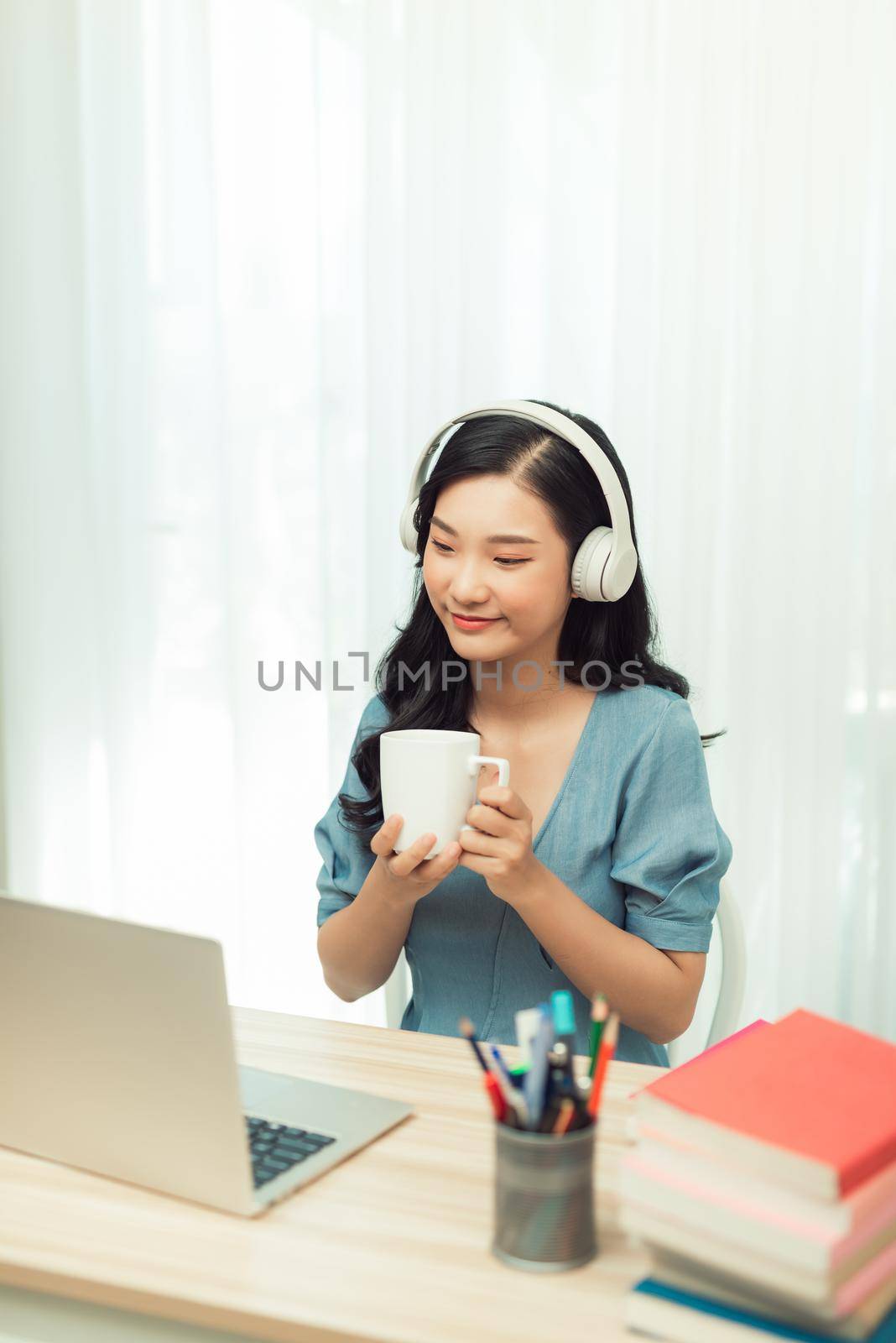 Smart asian  girl desk work remote laptop watch seminar drink beverage mug in house indoors by makidotvn
