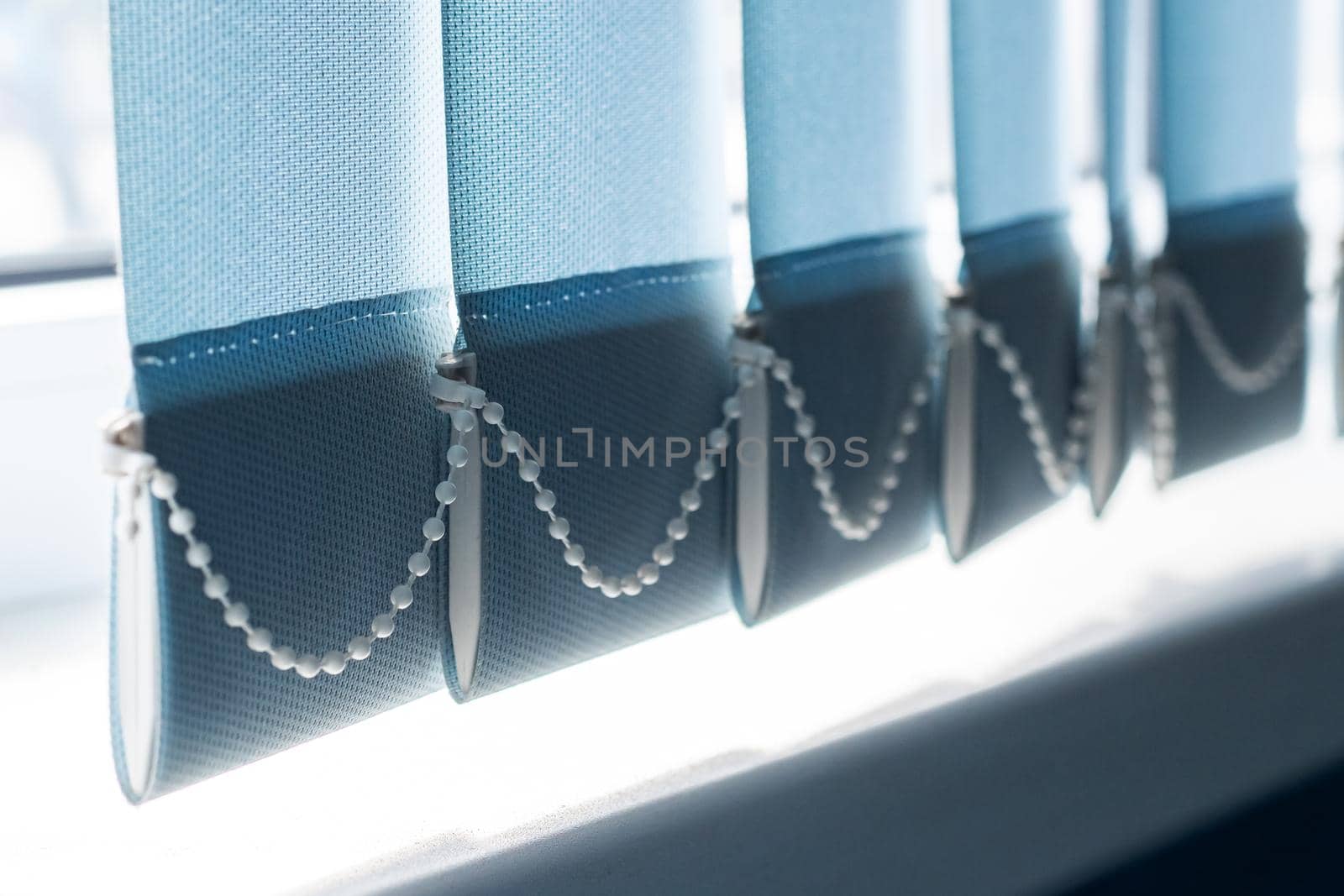 Blue fabric blinds on the window close up, sunlight