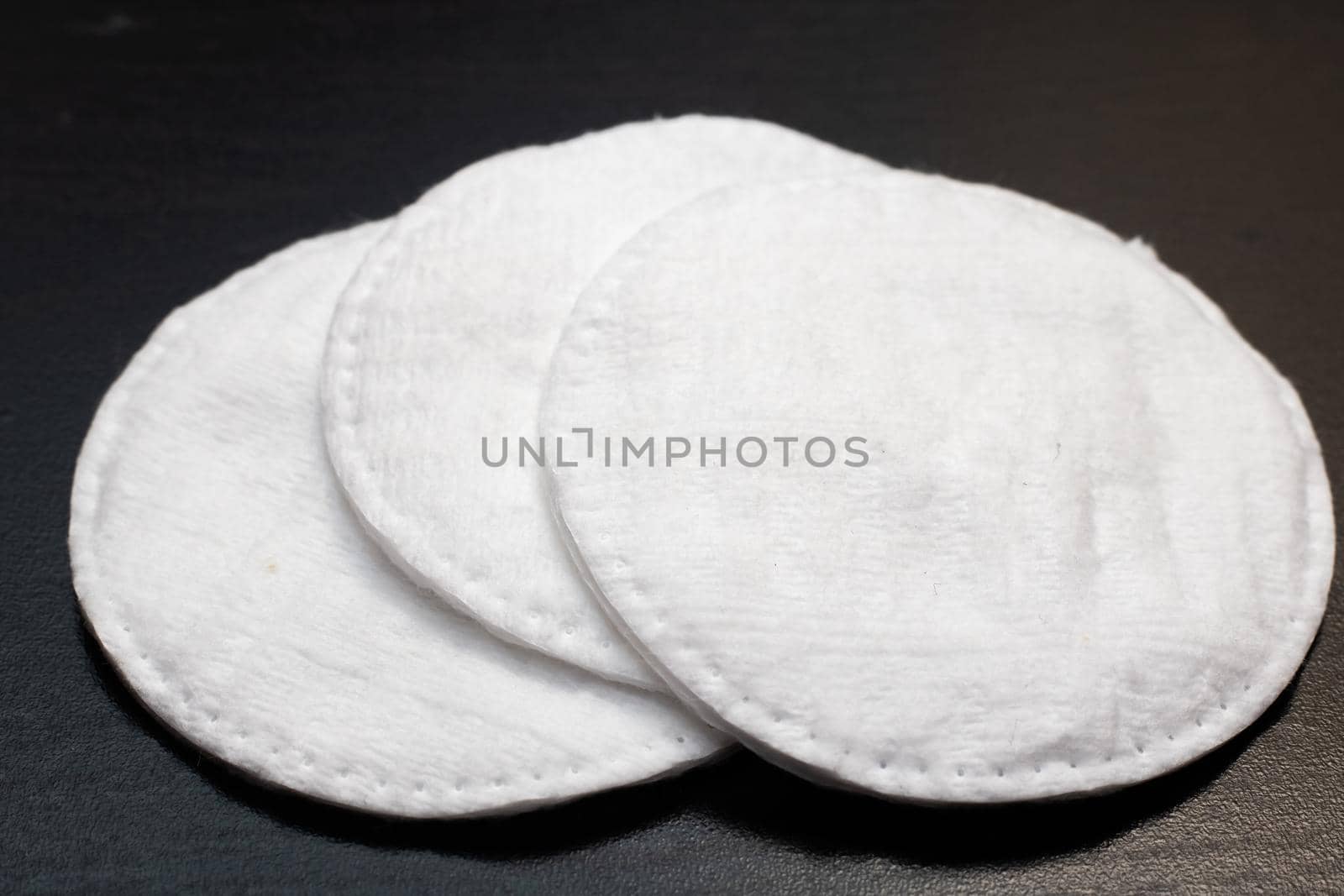 Three wadded disks on a black background close up, copy space