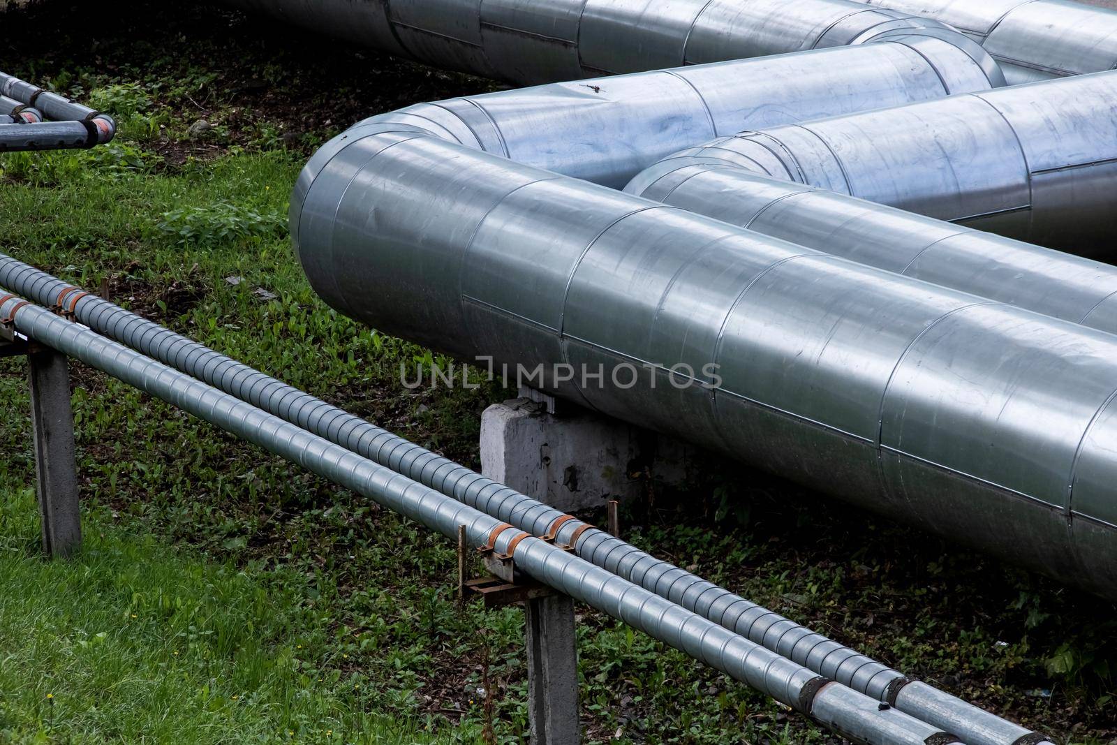 Metal water pipes above the ground close up, industrial elements