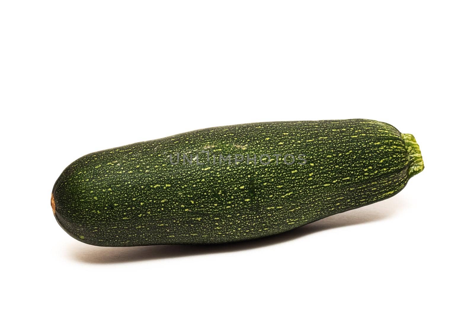 One green zucchini close up, isolated on a white background
