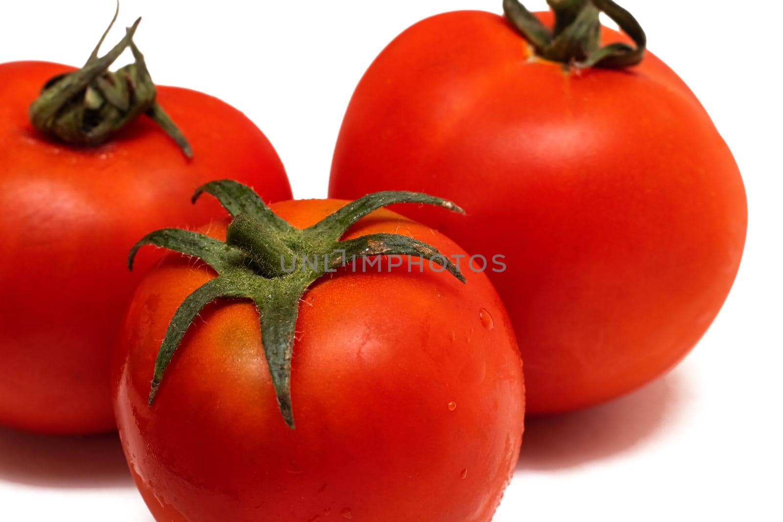 Red tomatoes close up, isolated on a white background
