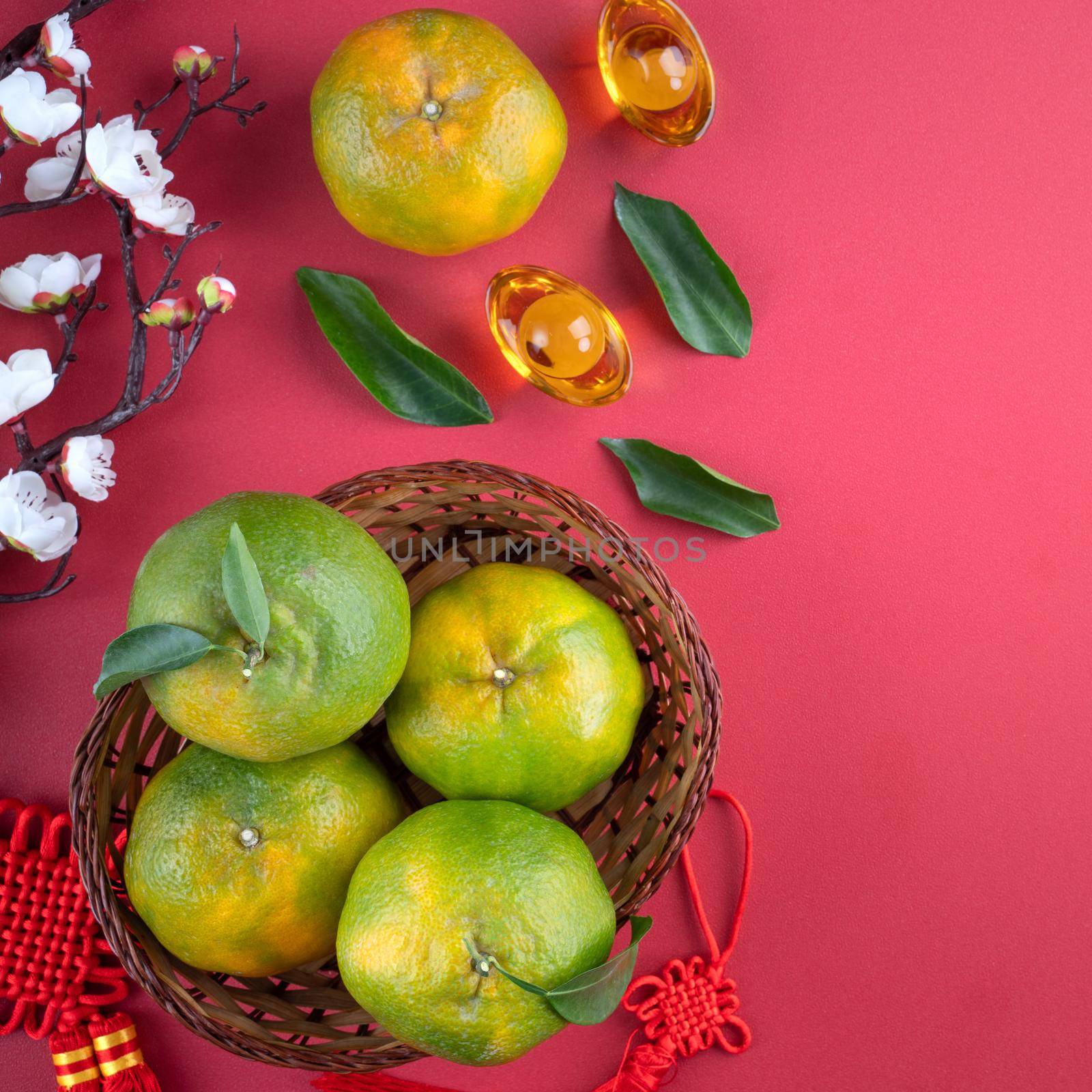 Top view of fresh ripe tangerine mandarin orange with fresh leaves on red table background for Chinese lunar new year fruit concept, the Chinese word means spring.