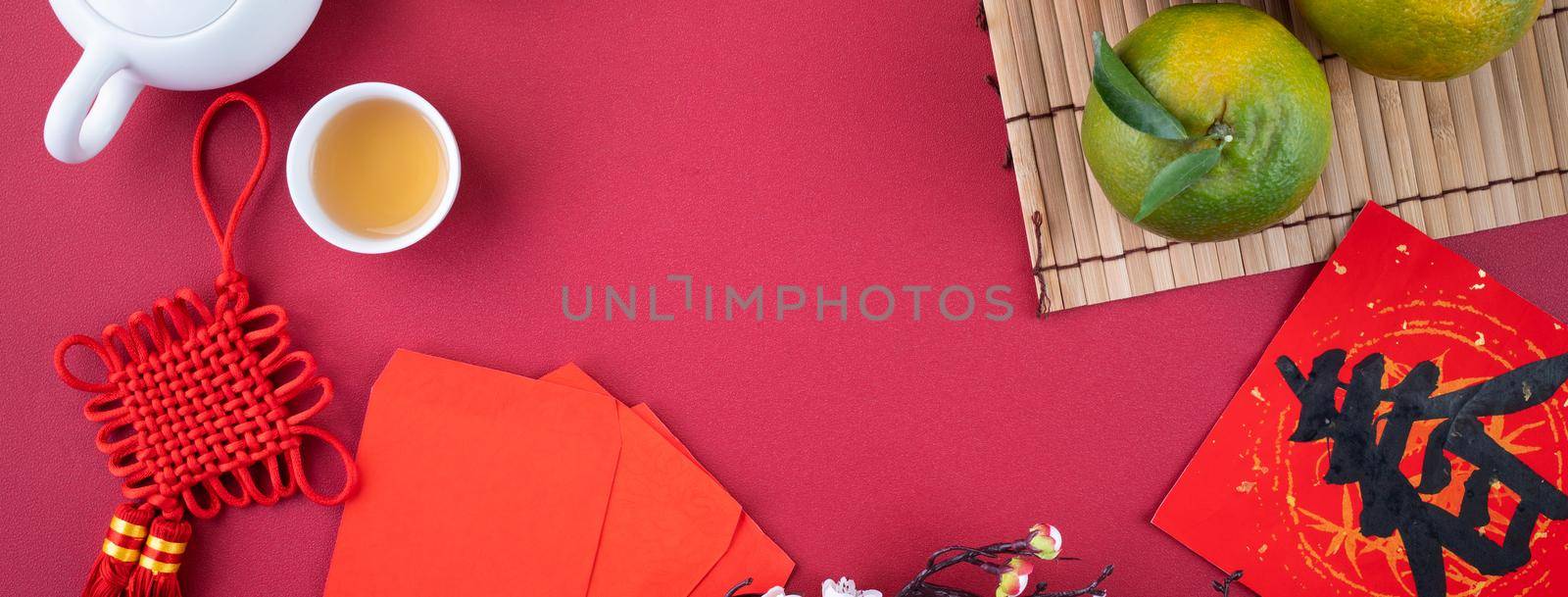 Top view of fresh ripe tangerine mandarin orange with fresh leaves on red table background for Chinese lunar new year fruit concept, the Chinese word means spring.