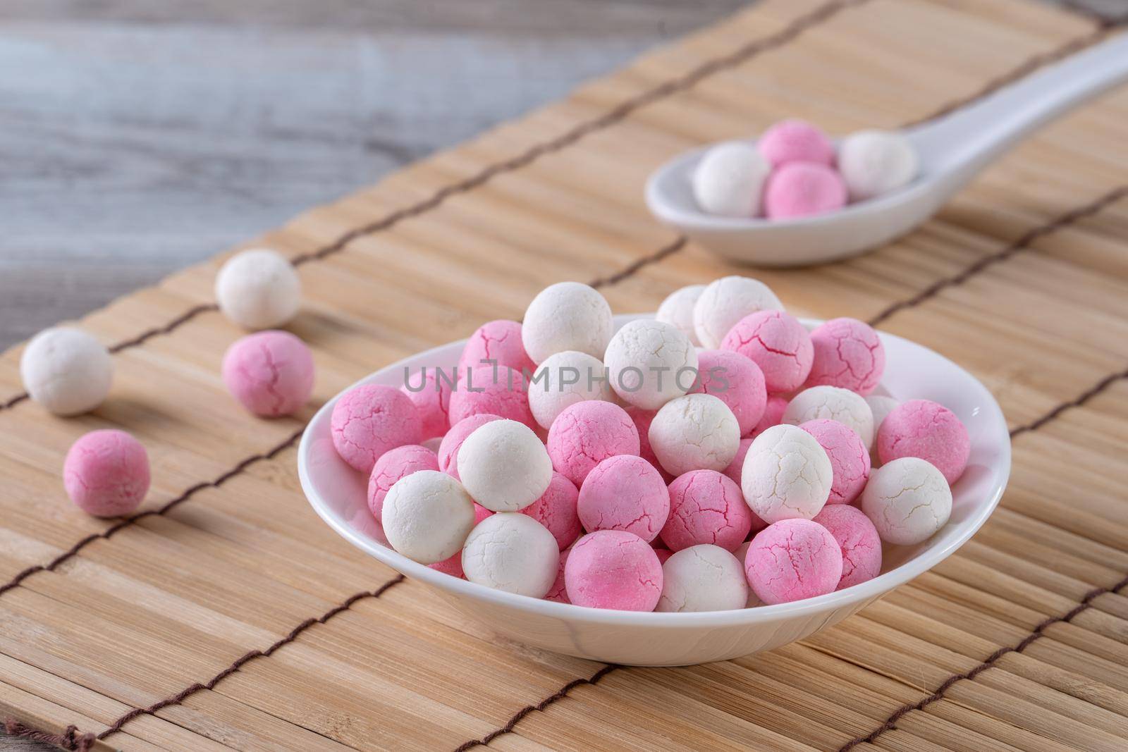 Raw red and white tangyuan glutinous rice dumpling balls on wooden table background for Winter solstice festival food.