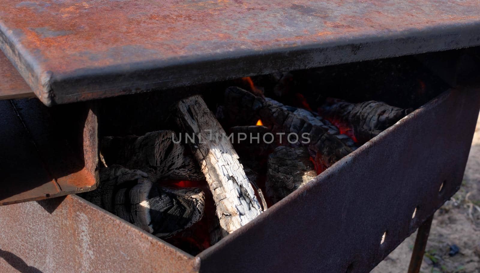 Makeshift iron smokehouse with Lid full of hot charcoal for Smoking Fish.