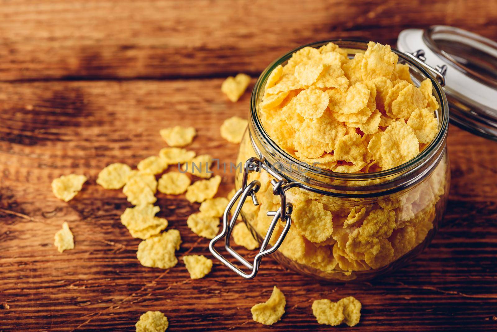 Jar full of corn flakes on a wooden surface