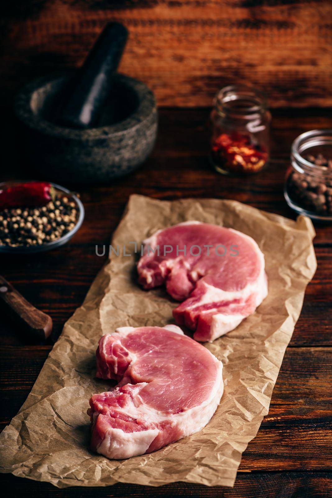 Pork loin steaks with ground spices on baking paper