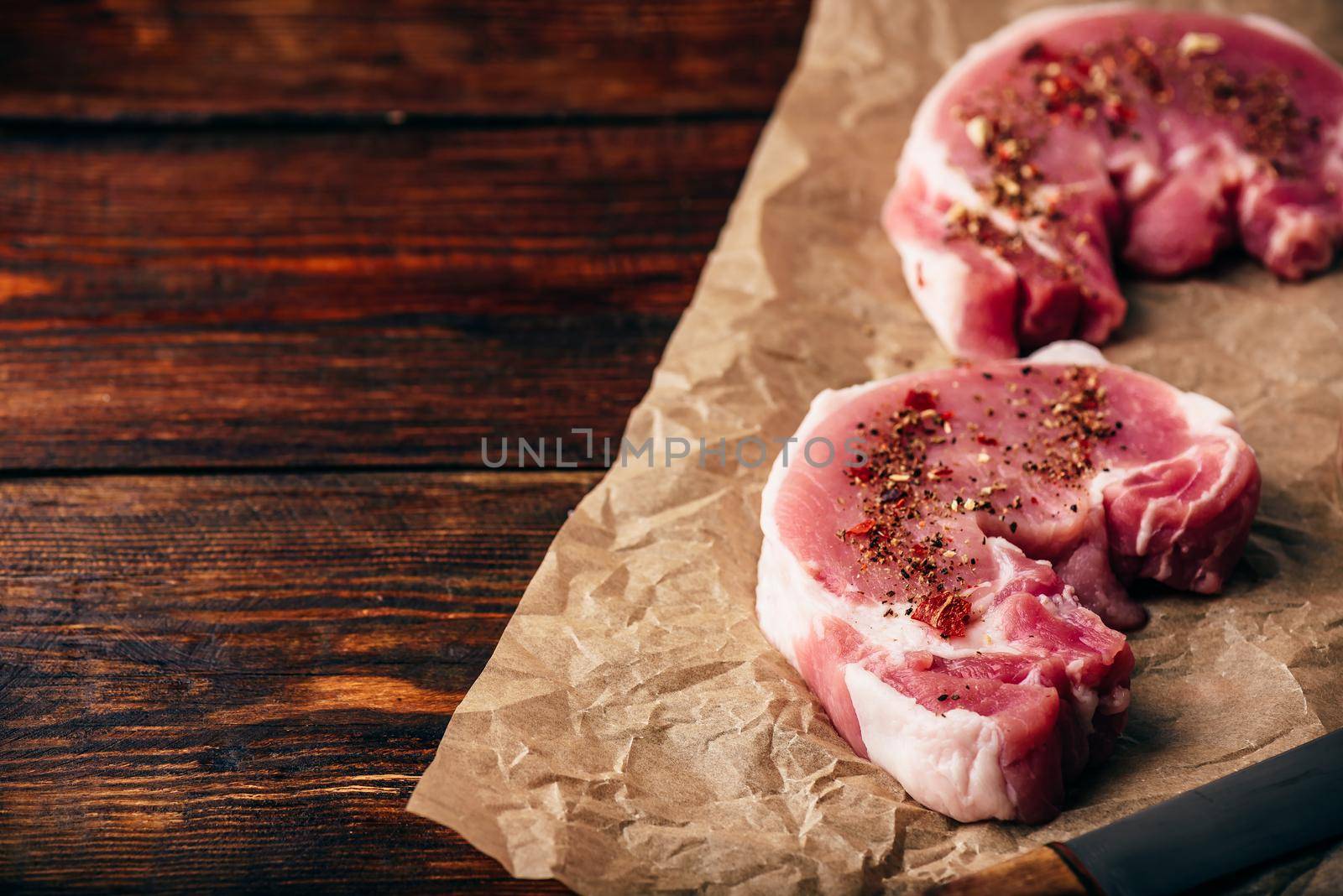 Pork loin steaks with ground spices on baking paper