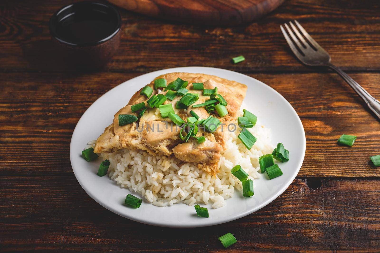 White rice with scrambled eggs with chicken and green onion on plate