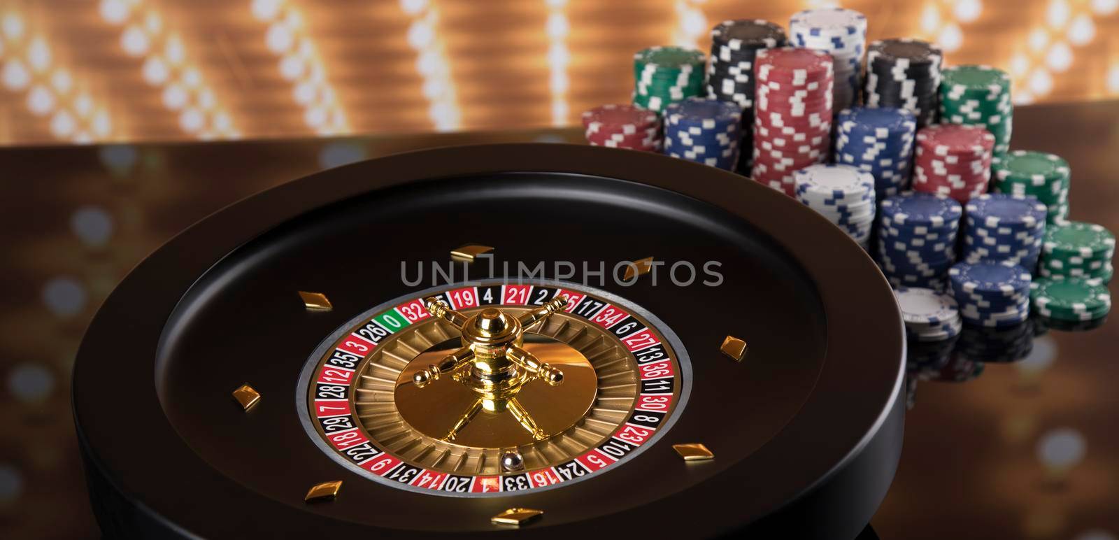 Poker Chips on gaming table, roulette wheel in motion, casino background