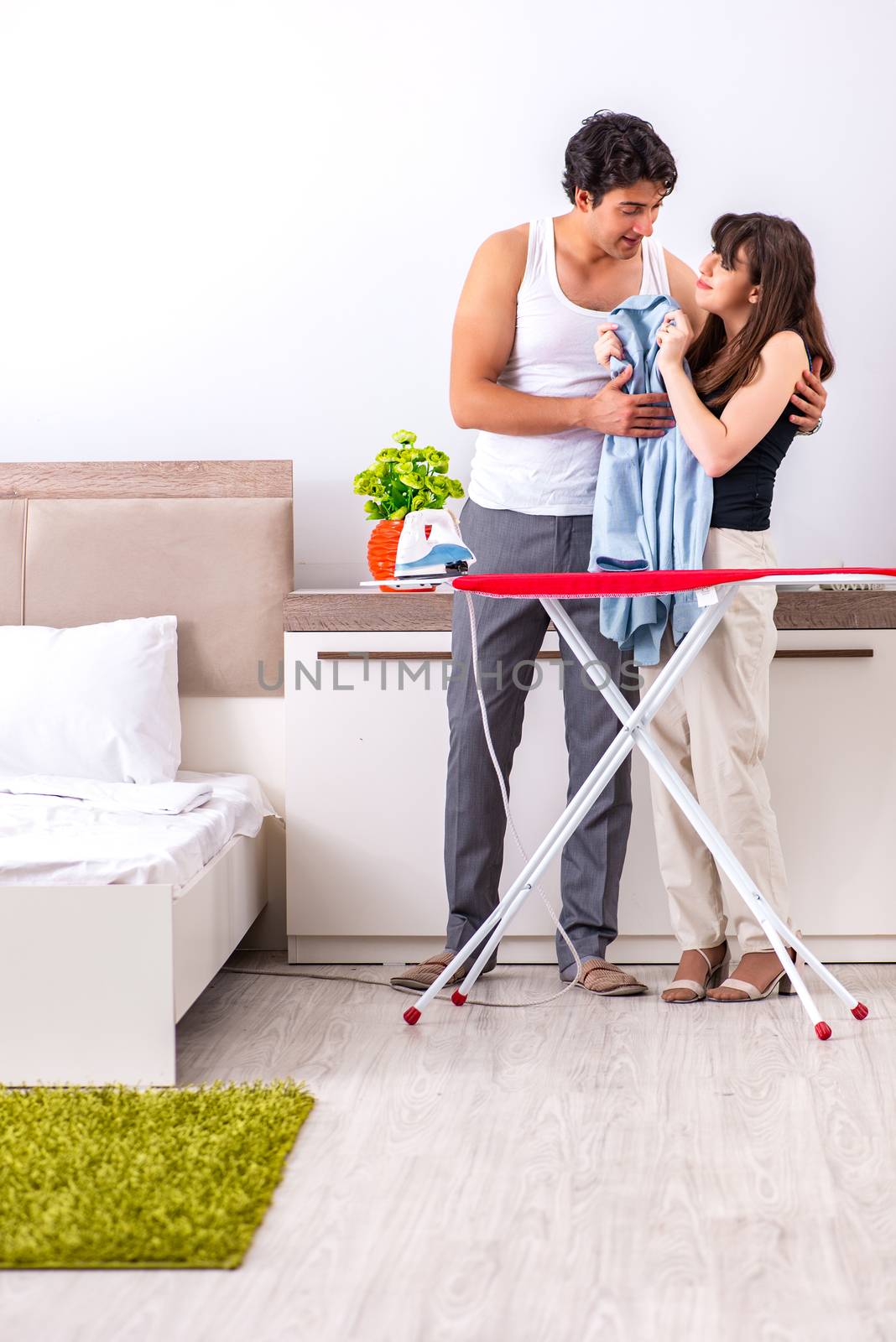 Young woman doing ironing for her husband