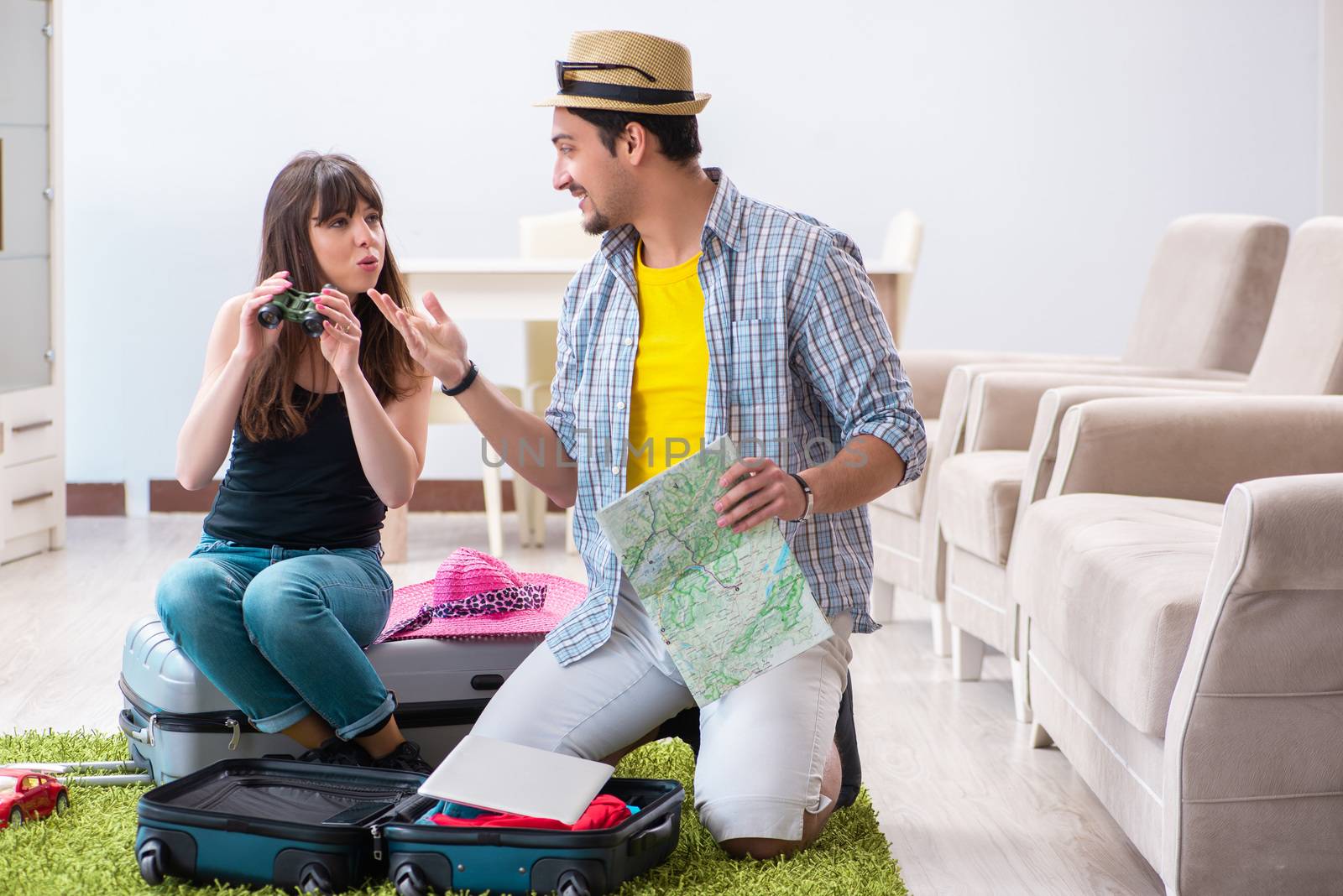 Young family packing for vacation travel by Elnur