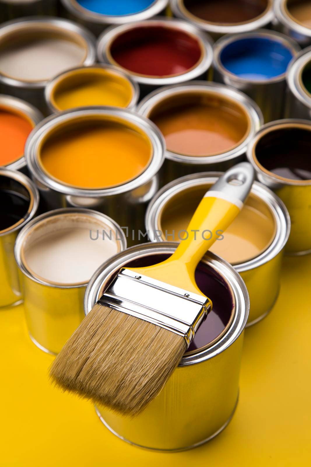 Tin cans with paint, brushes and bright palette of colors