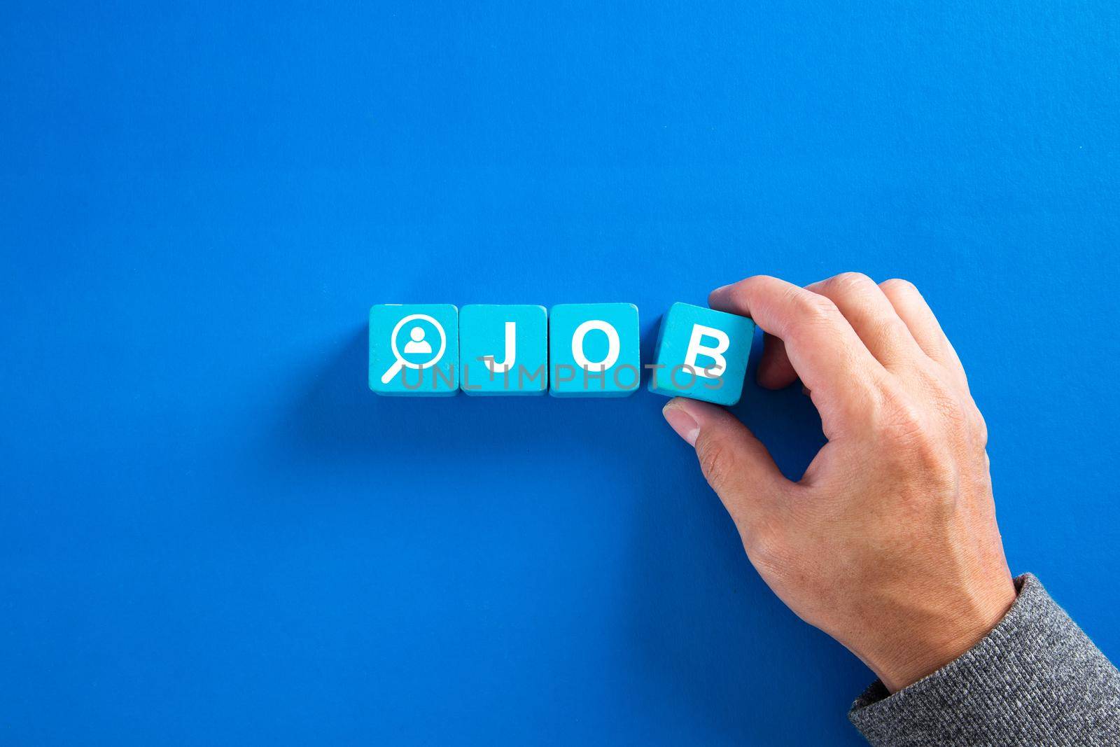 The word job on wooden cubes with on blue background. Searching for a job, employment, recruitment or career concept. by tehcheesiong