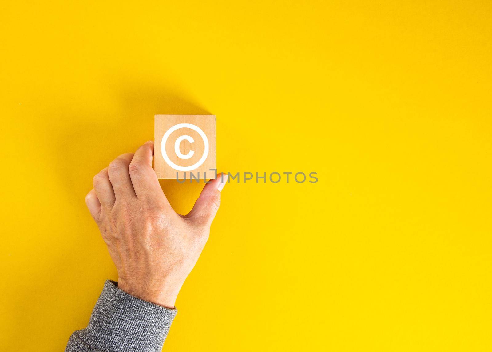 Businessman hand holding a copyright symbol. Property rights and brand patent protection. by tehcheesiong