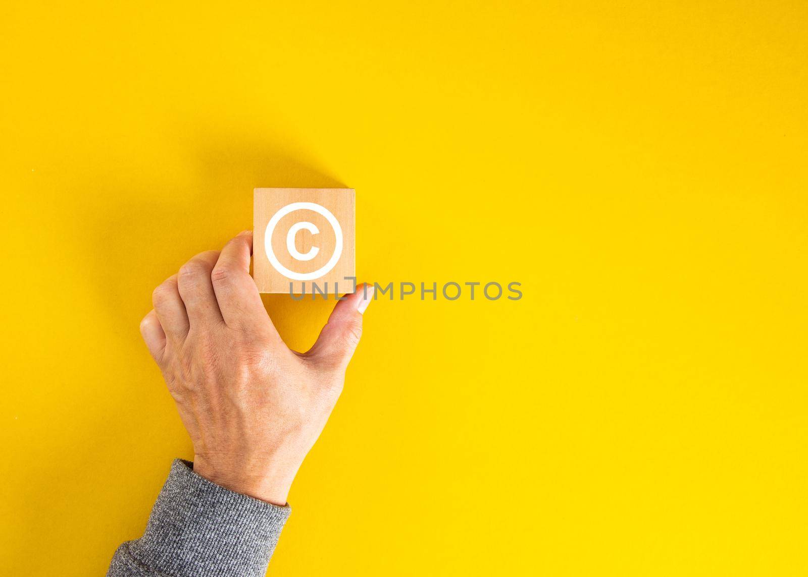 Businessman hand holding a copyright symbol. Property rights and brand patent protection in business concept.